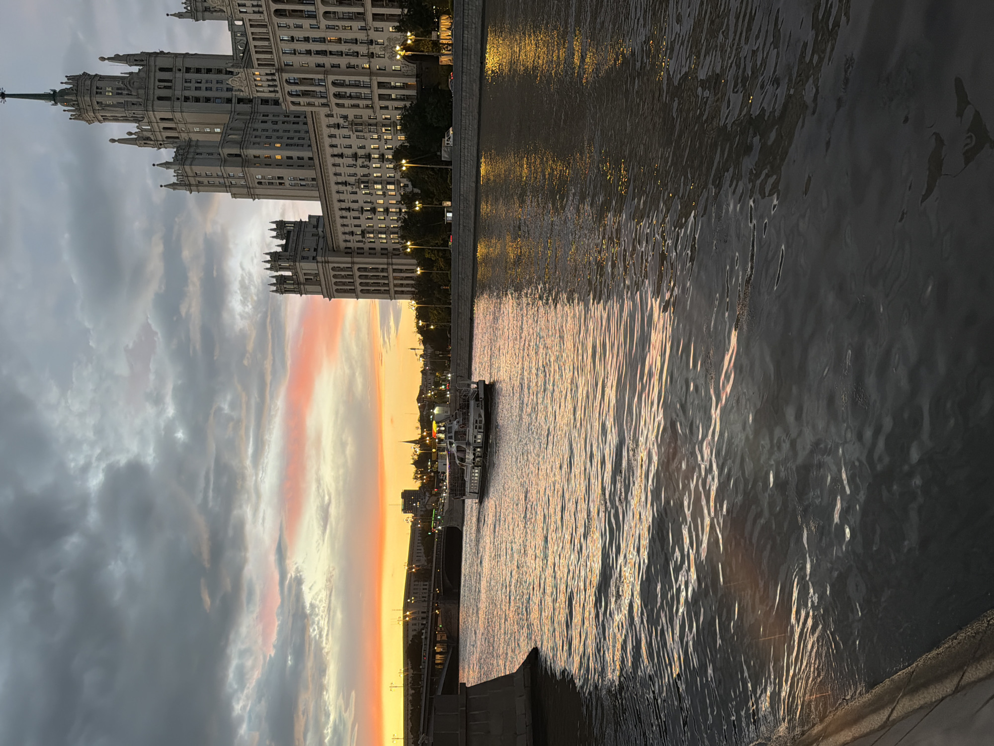 Moscow riverside at golden hour, Stalinist tower and stormy sunset sky