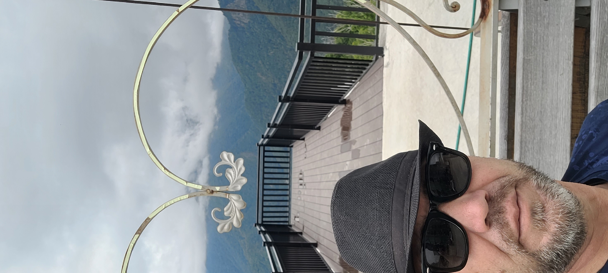 Observation deck selfie overlooking Milisi's forested mountain range