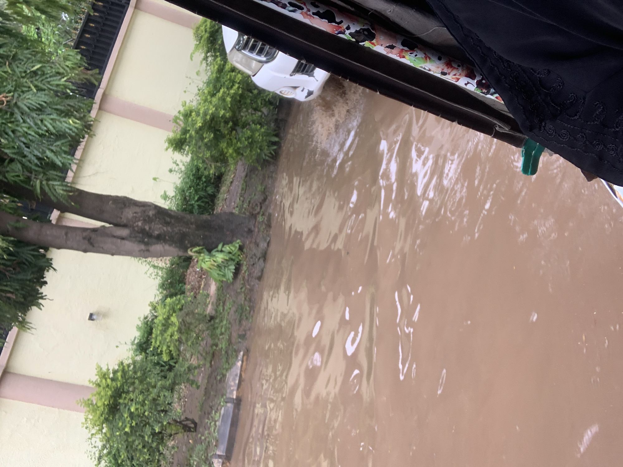 Everyday life inside an Abuja home, flooding visible outside