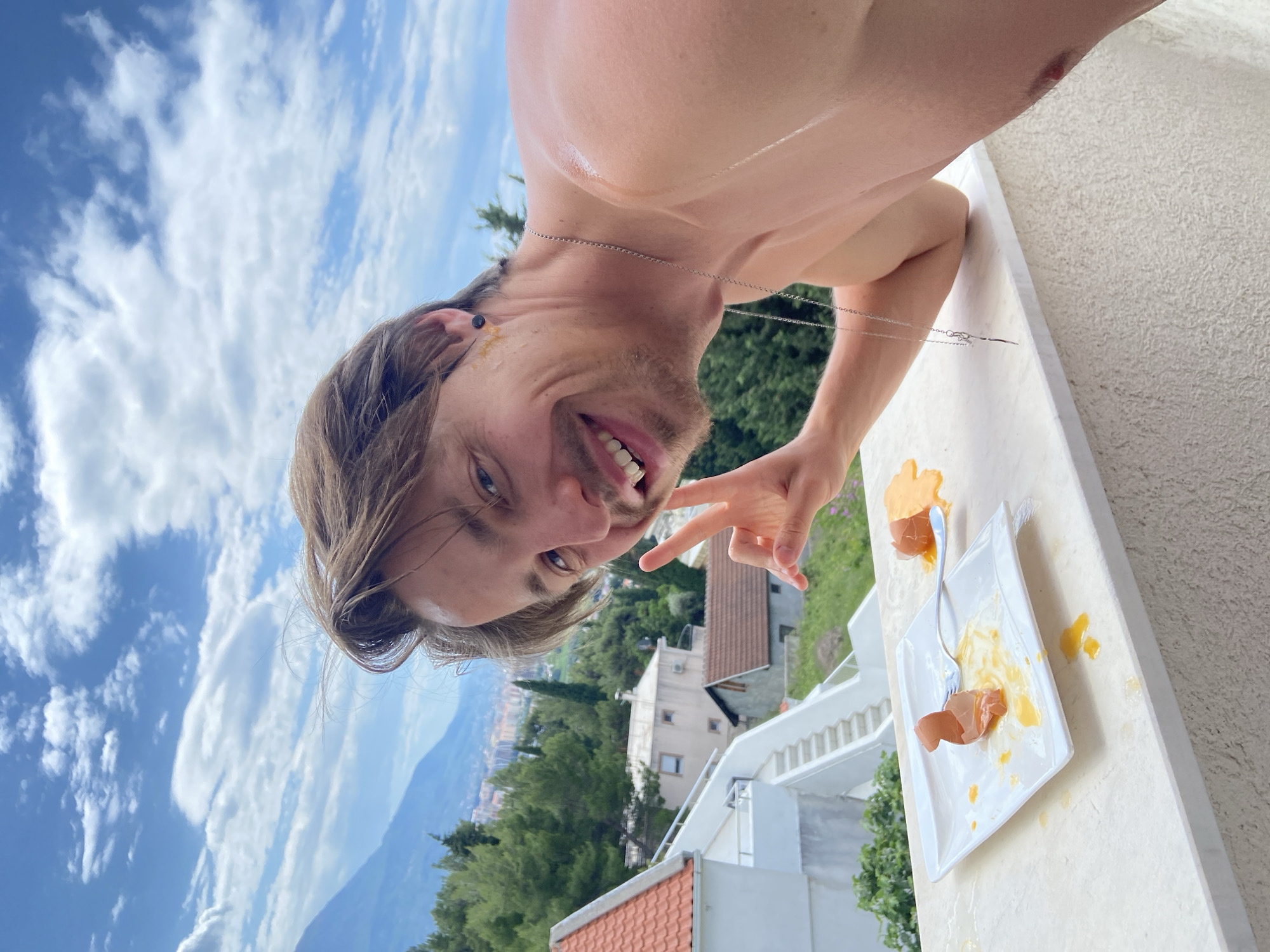 Man poses for skincare content on Montenegro balcony