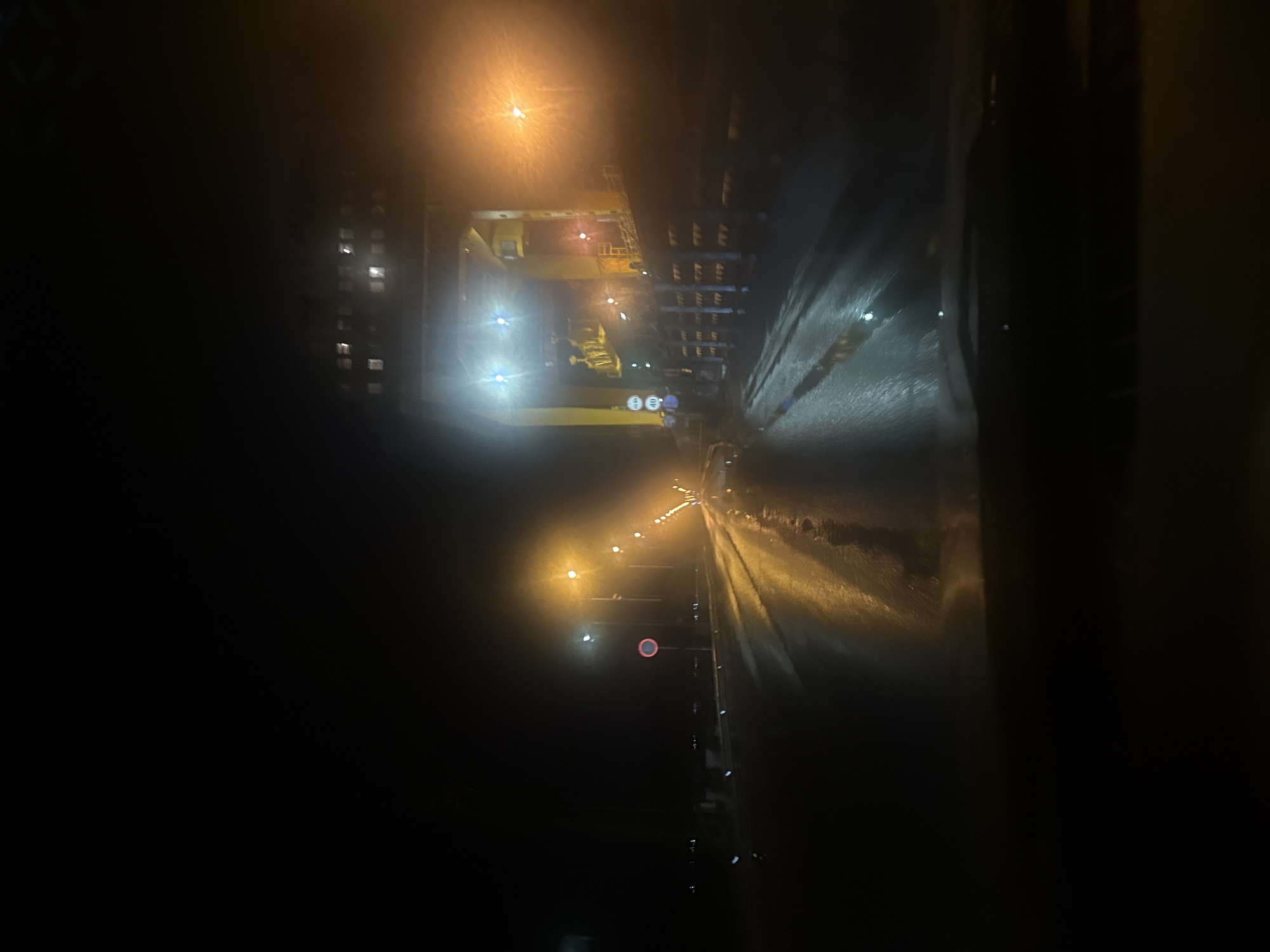 Wet nighttime street scene captured in Chaikovsky, Russia