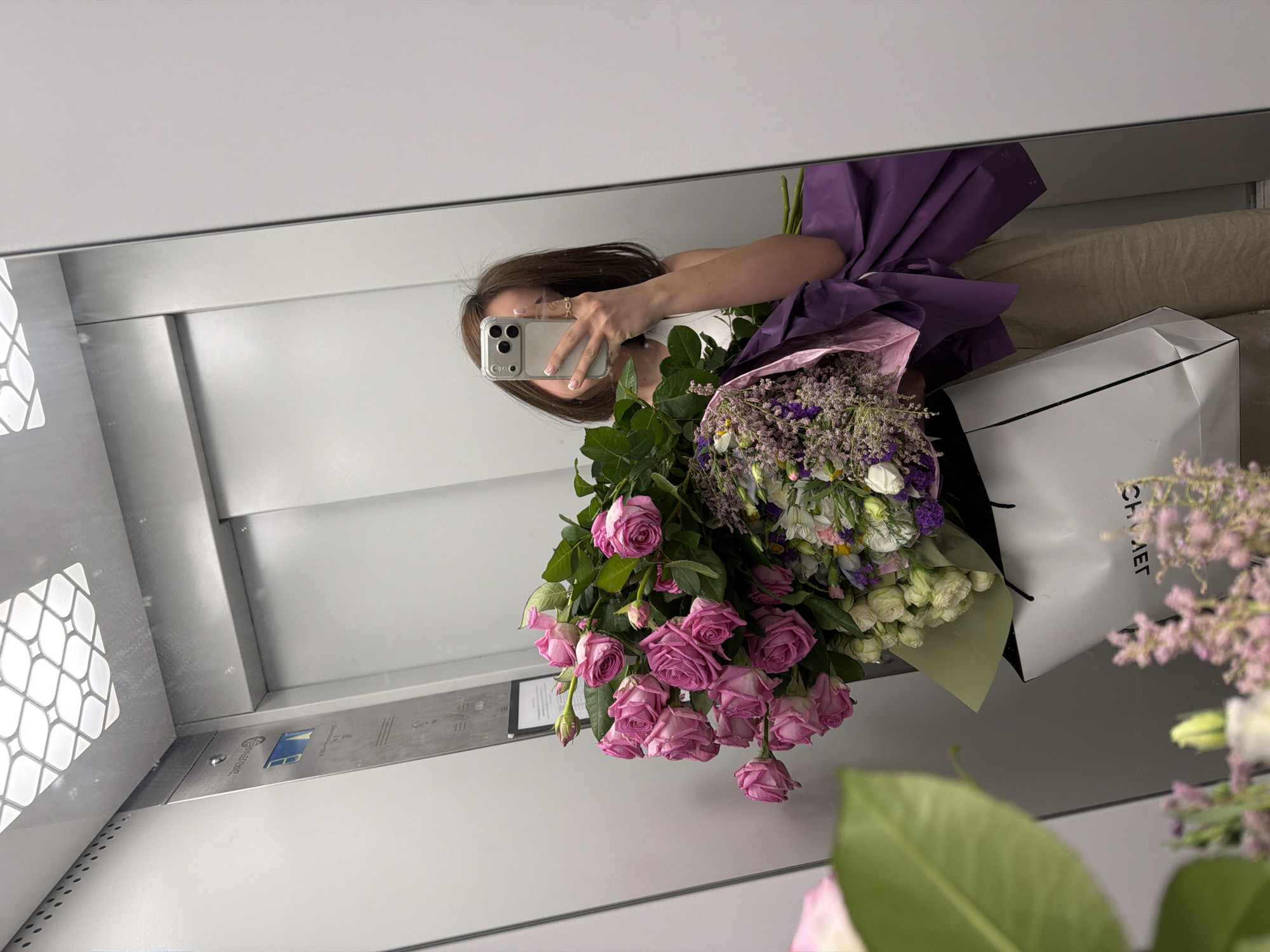 Woman takes elevator selfie with flower bouquet in Yerevan