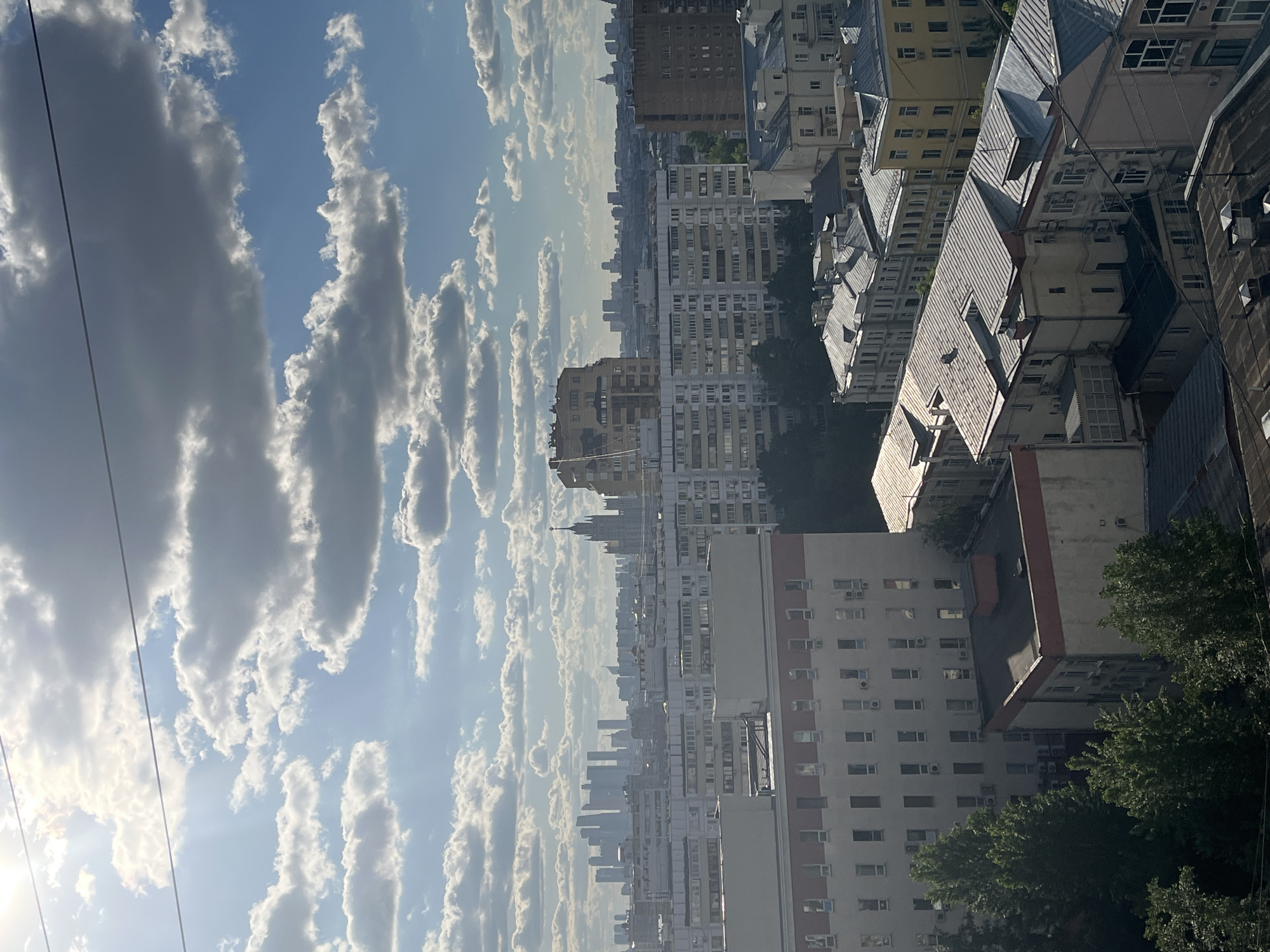 Cityscape viewed from elevated position under partly cloudy skies