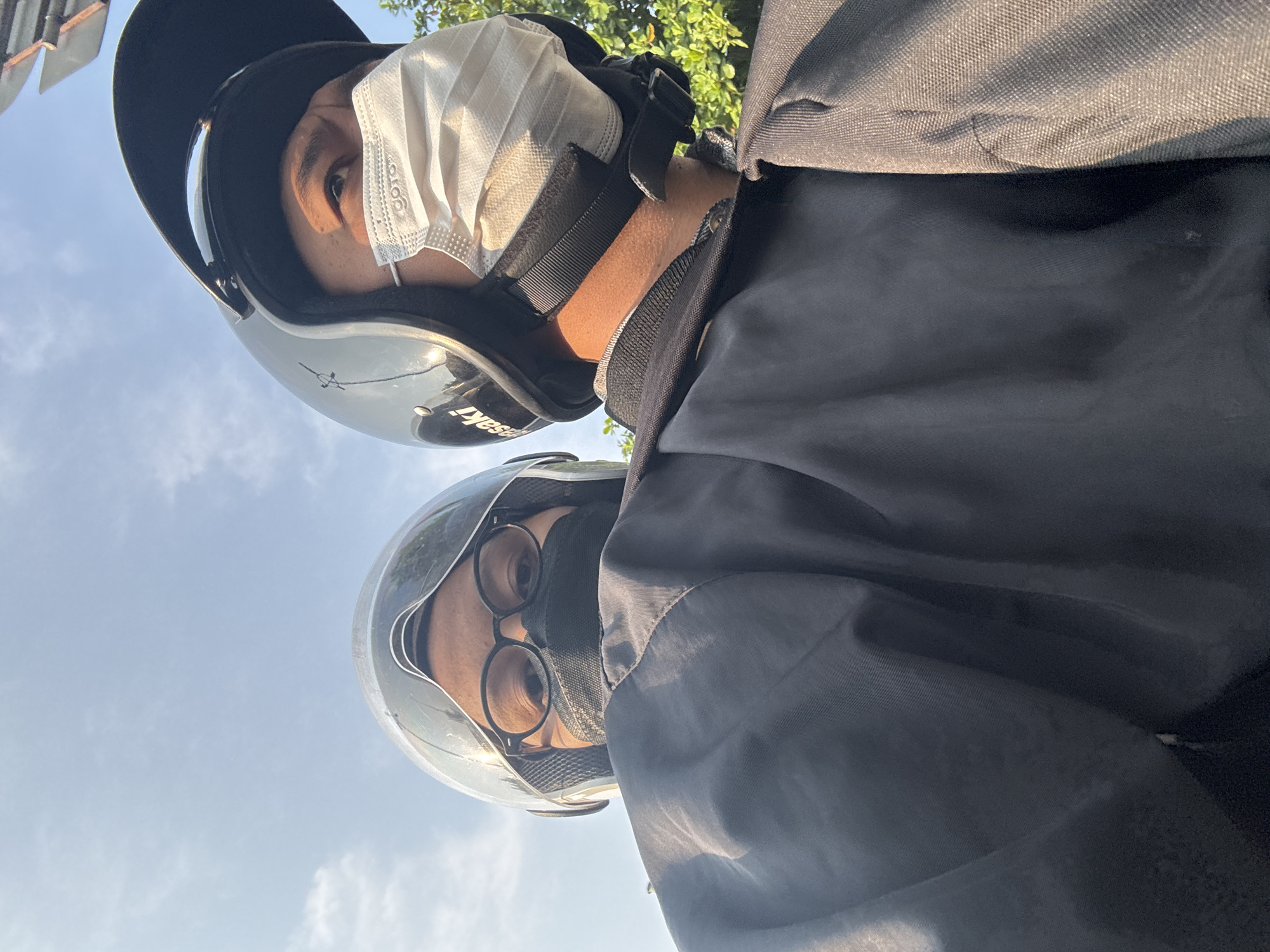 Masked motorcyclists pause at a West Jakarta traffic light