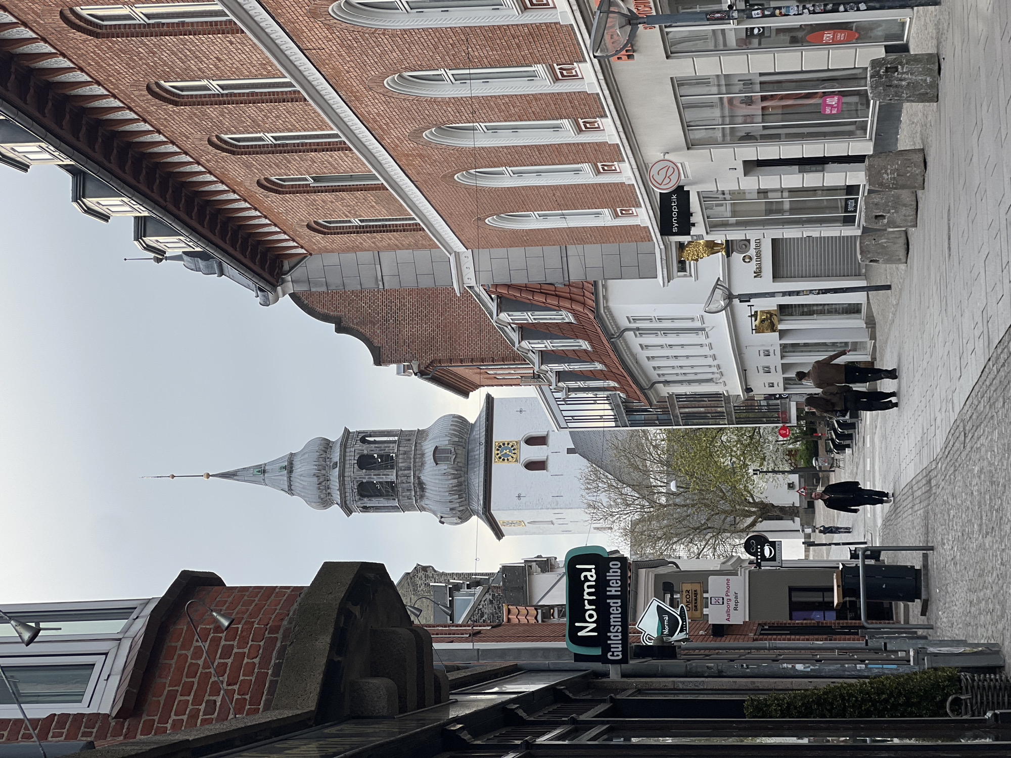 Tourist documents spring afternoon walk through historic Aalborg streets
