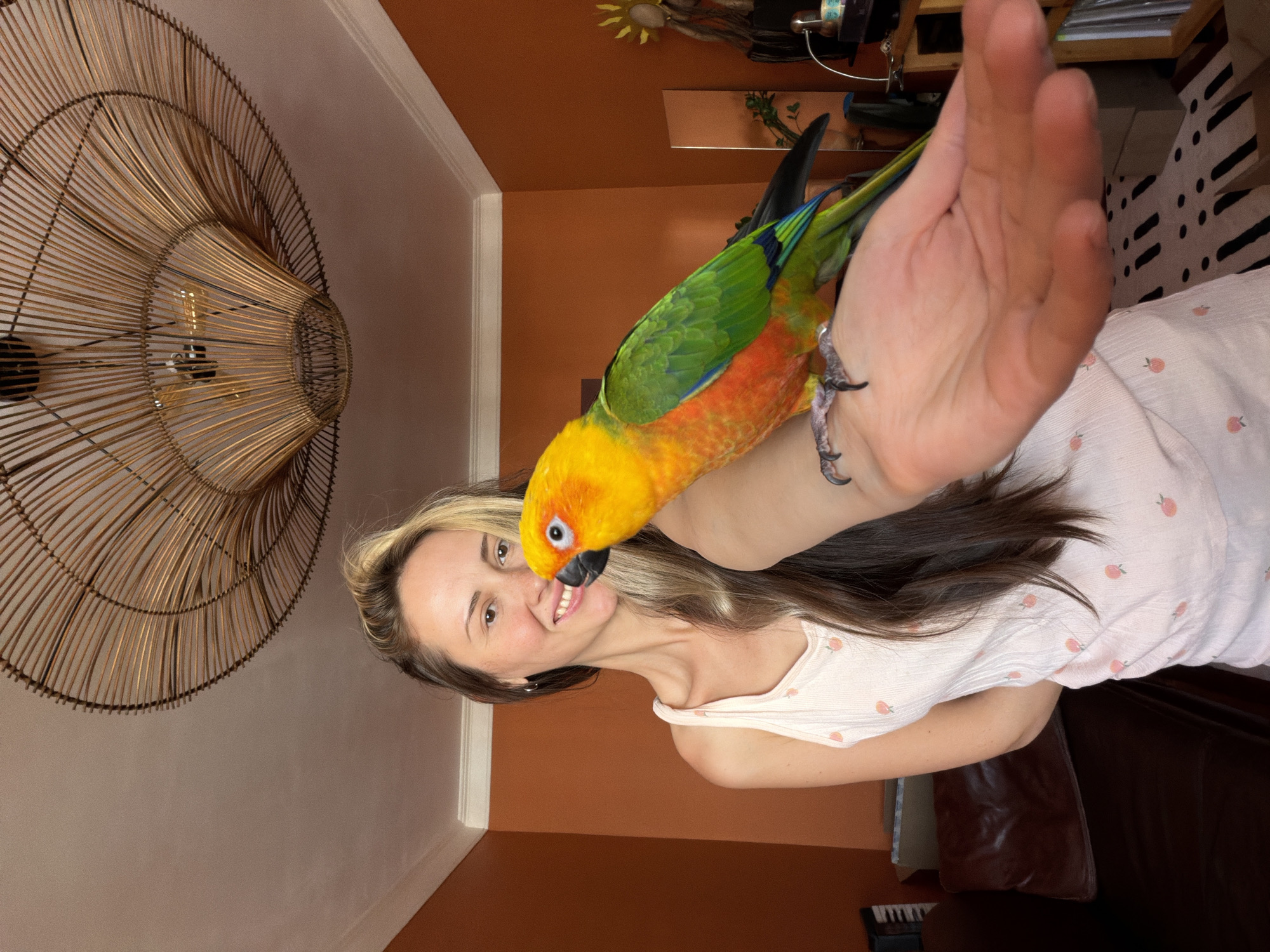 Woman poses with Sun Conure parrot in Khimki home