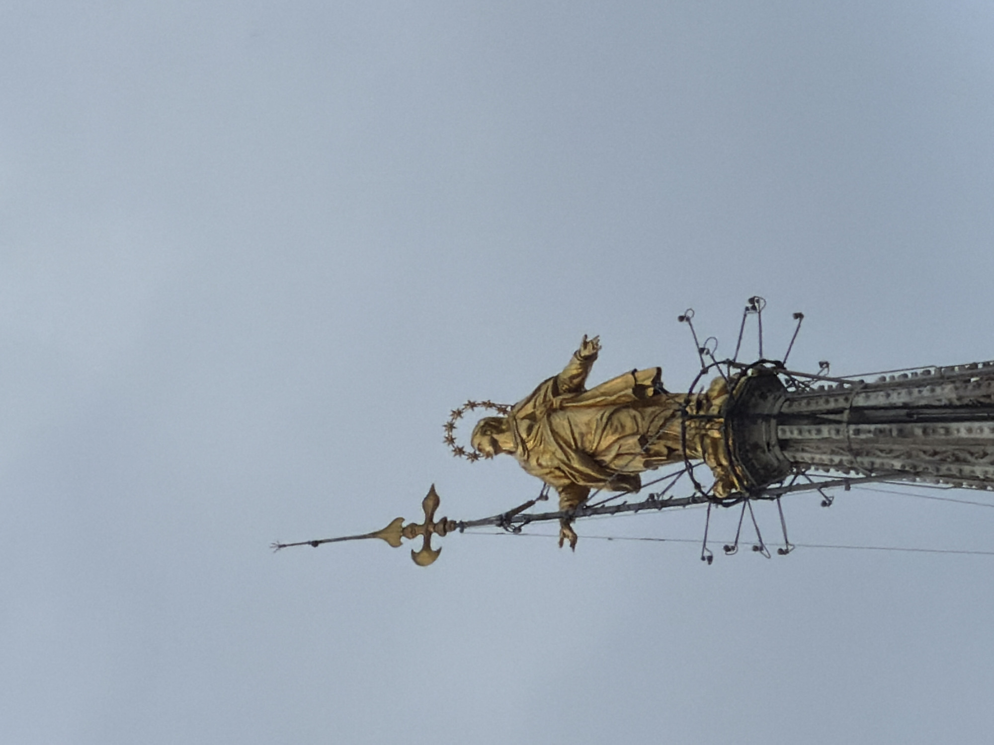 Visitor documents Milan Cathedral's Gothic details and golden Madonnina statue