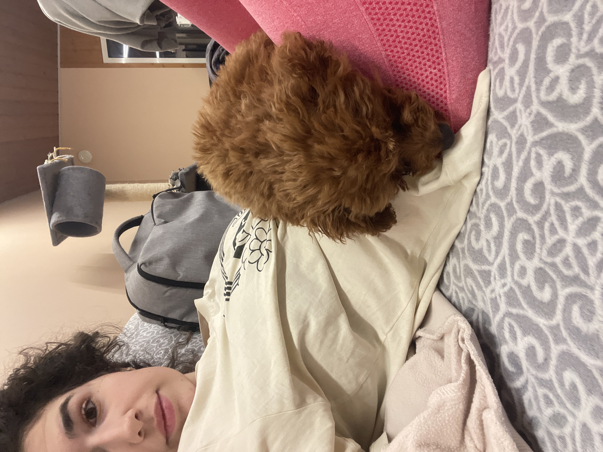 Woman and small dog rest together on couch in Sofia