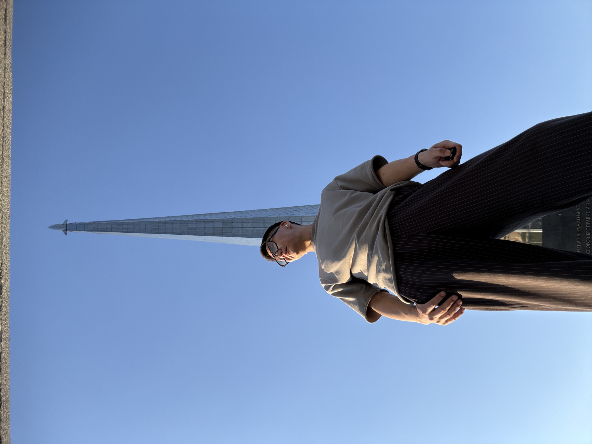 Tourist photographs space monuments in Moscow during afternoon visit