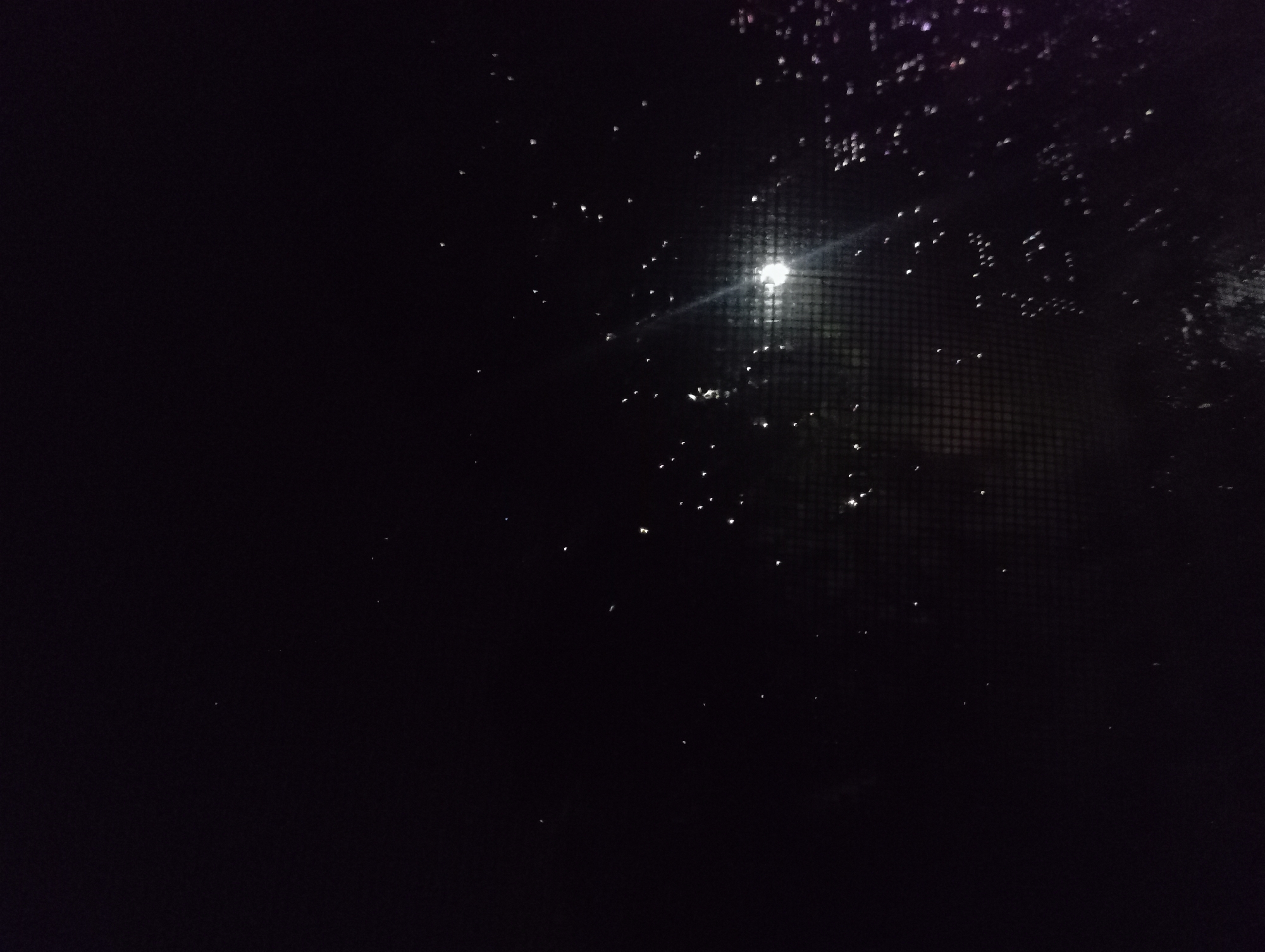 Rainy night scene captured through window in Nkpor, Nigeria