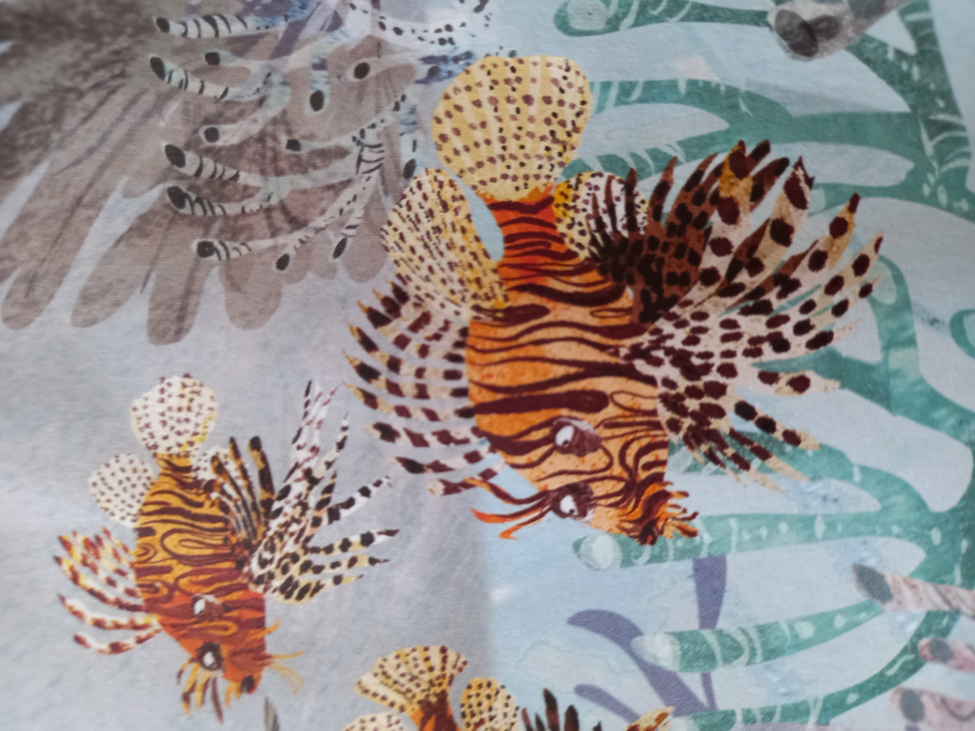 Colorful reef fish illustrations on fabric in Baan Mae Nam