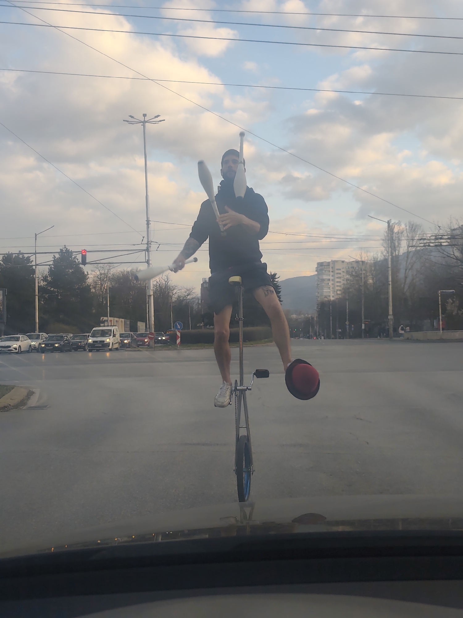 Street performer unicycles in Sofia intersection near Vitosha Mountain