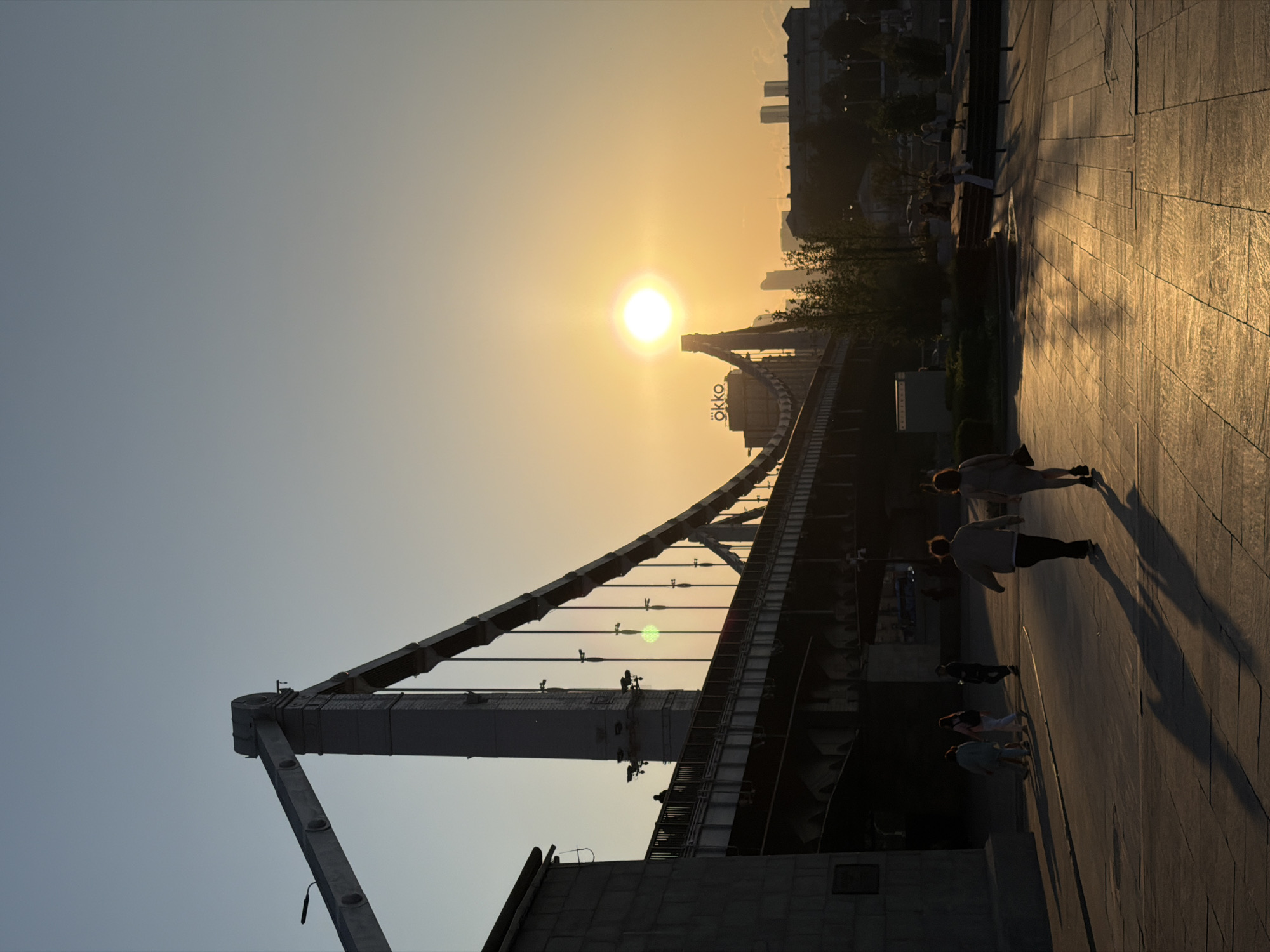 Sunset silhouettes city bridge in golden evening sky