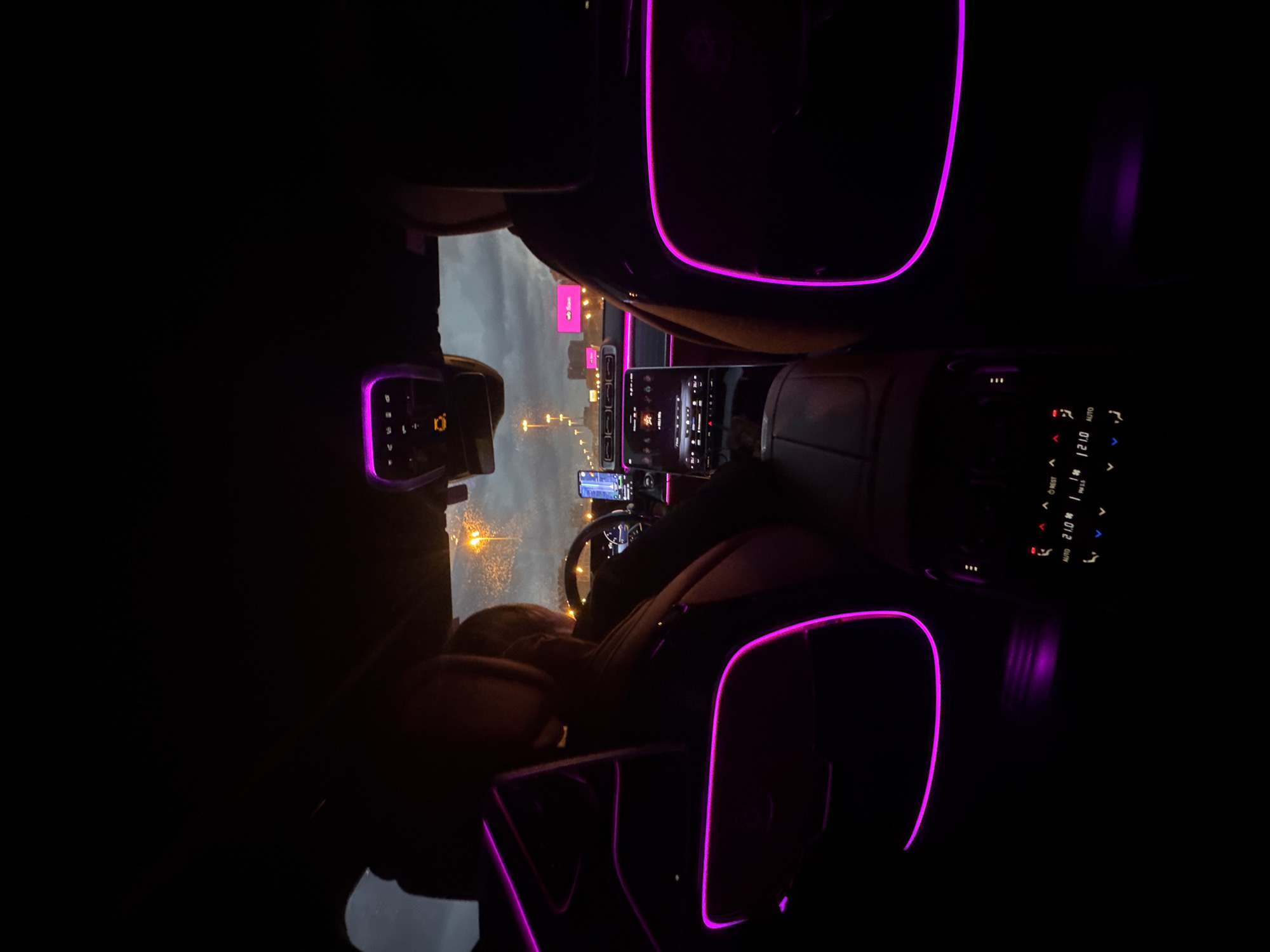Luxury car interior glowing with purple ambient light at night