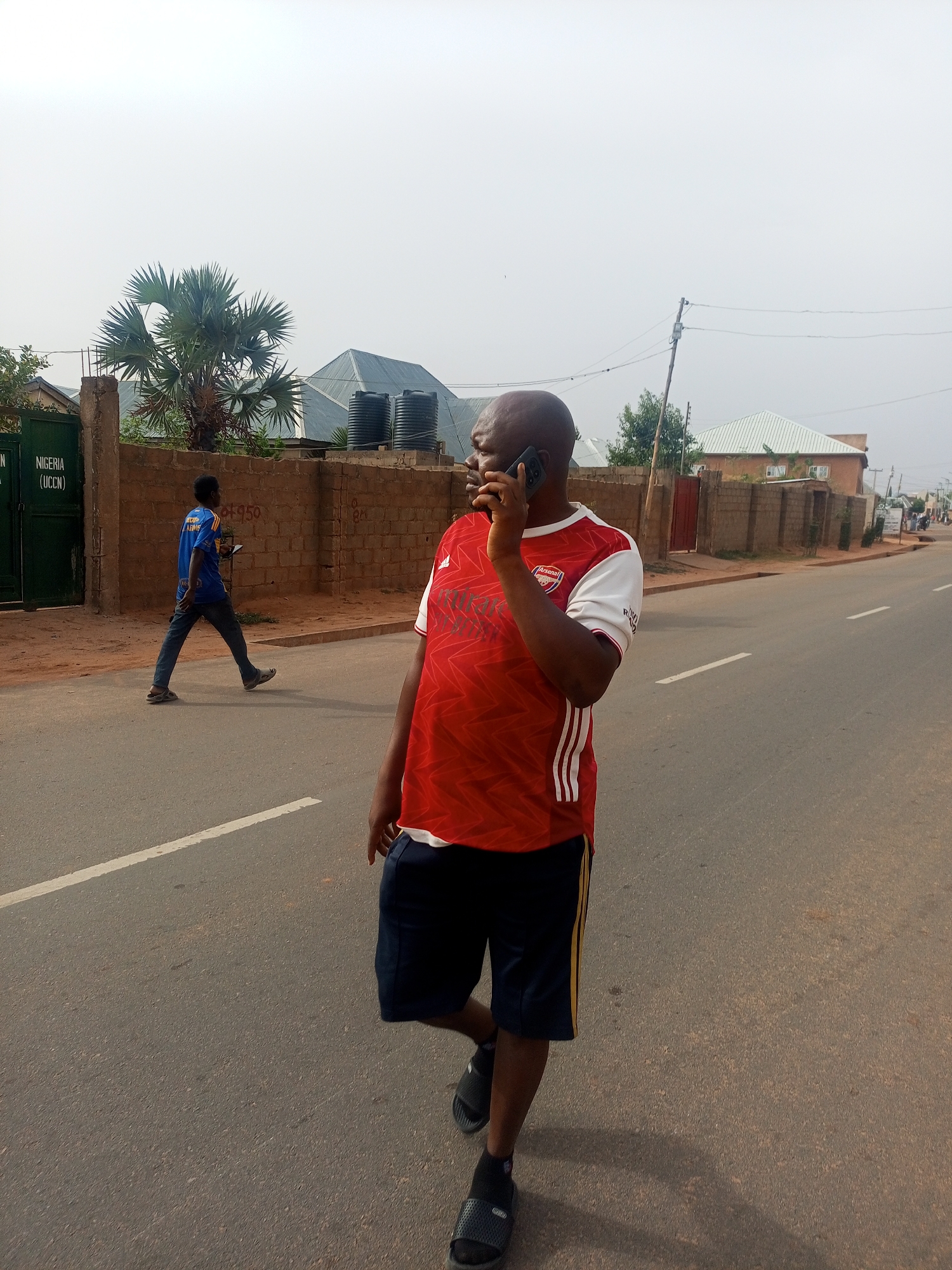 Morning pedestrians navigate Tempure streets in traditional Nigerian town