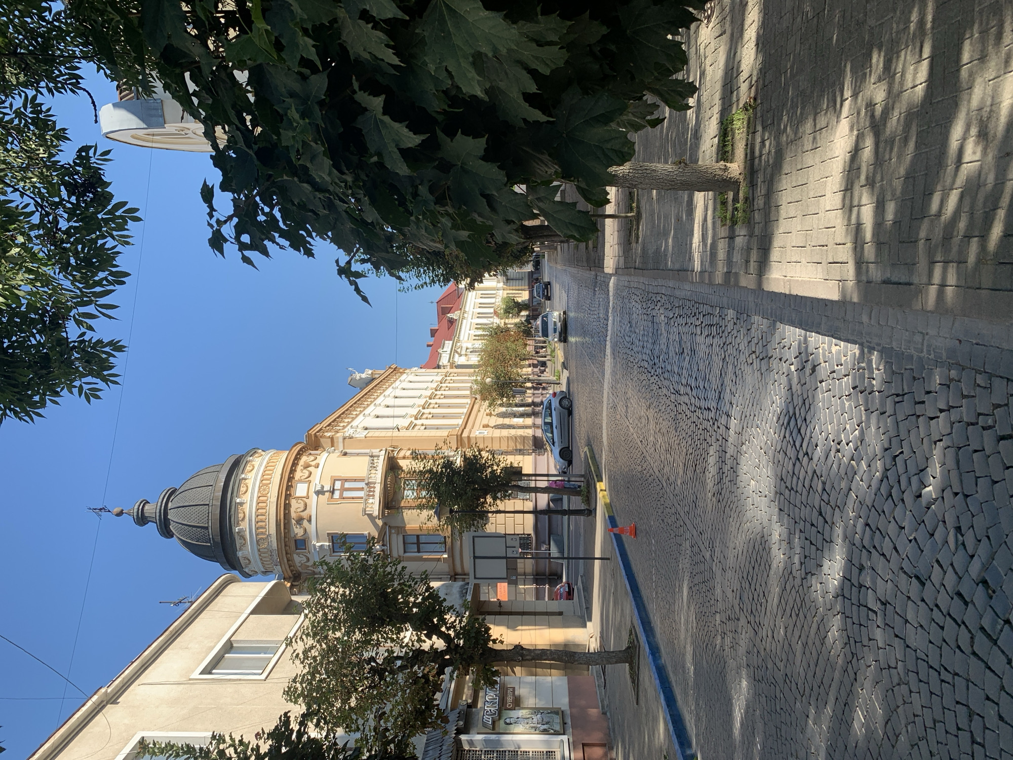 Kolomyia's domed historic building on a sunny cobblestone street