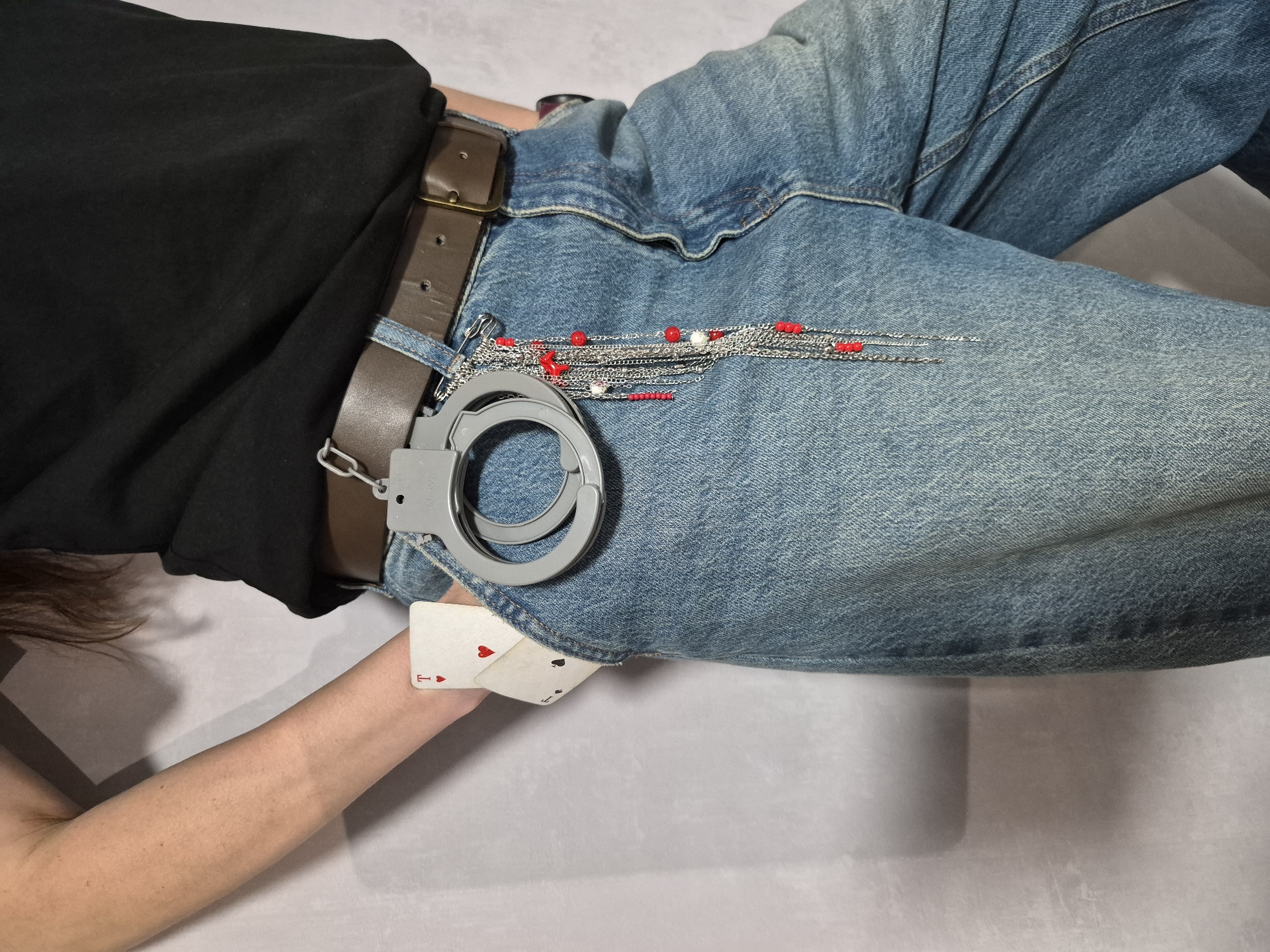 Person documents belongings, cards, handcuffs during casual pizza meal