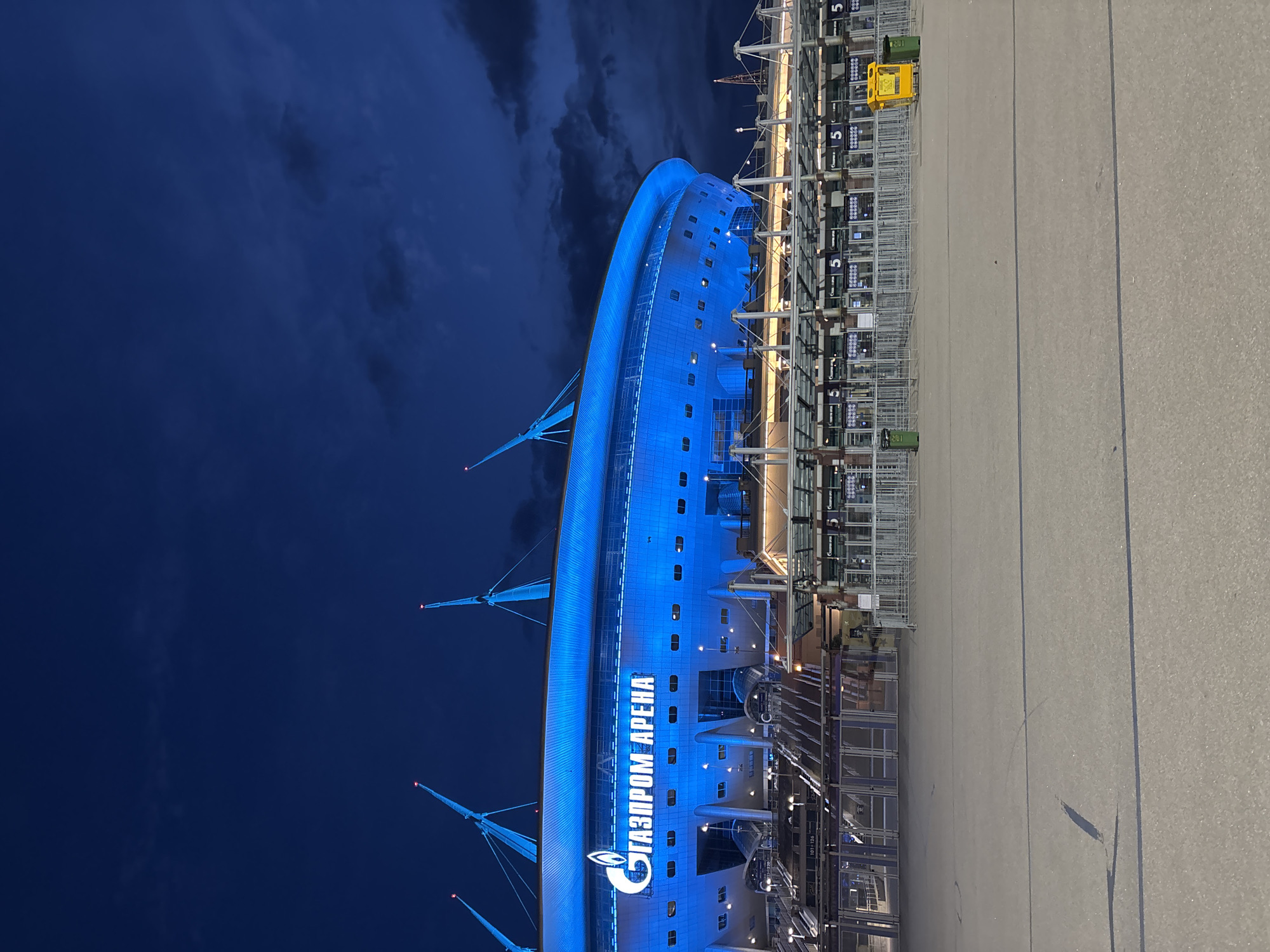 Gazprom Arena glows blue against dramatic evening sky