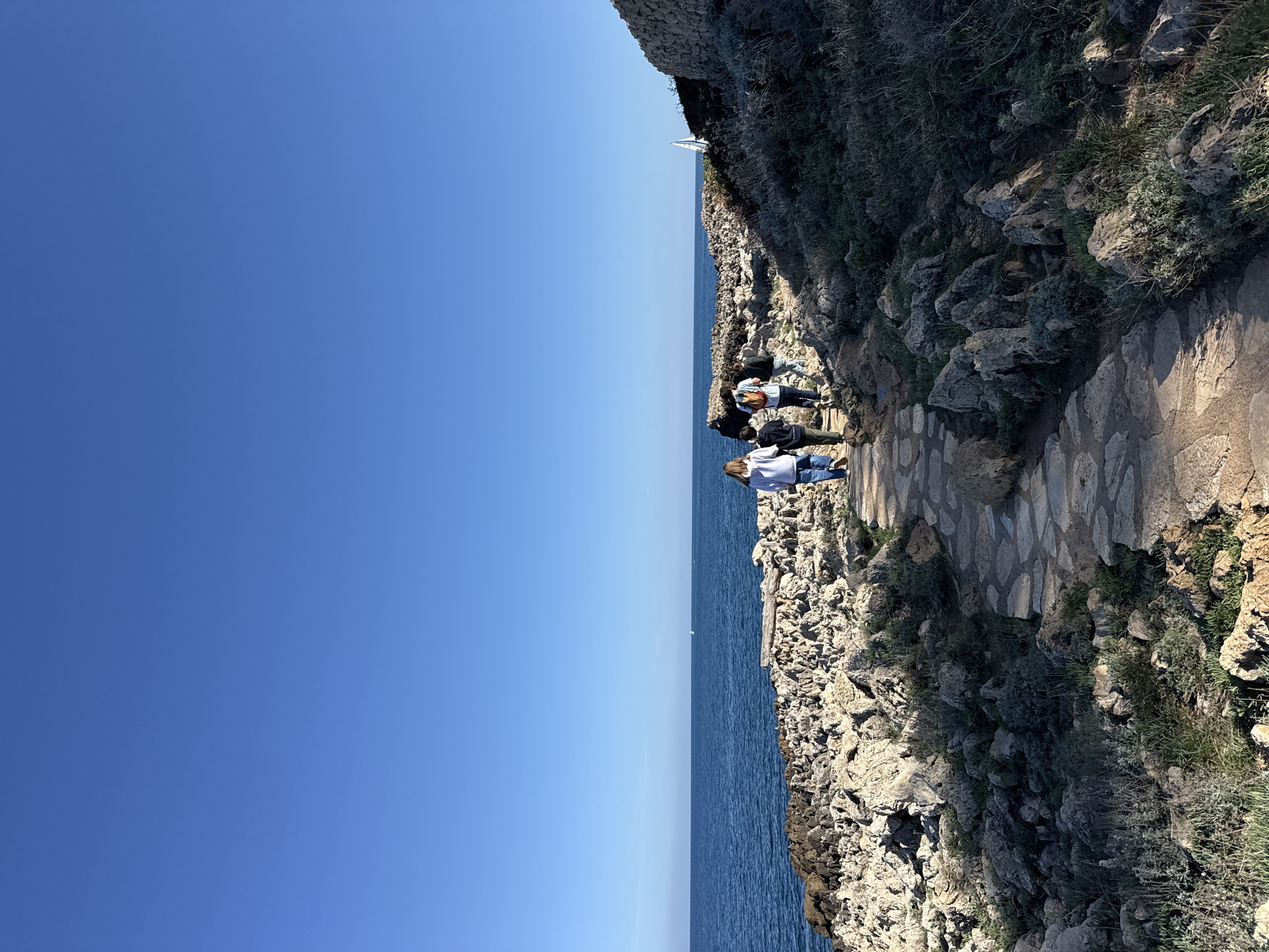 Visitors stroll coastal pathway in Antibes, France