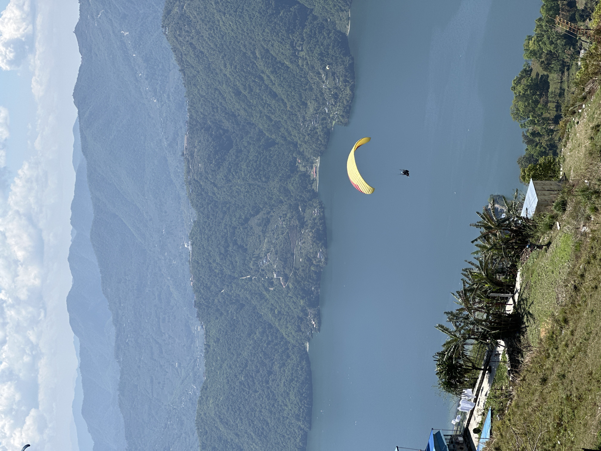 Paragliders soar over Phewa Lake in early morning flight