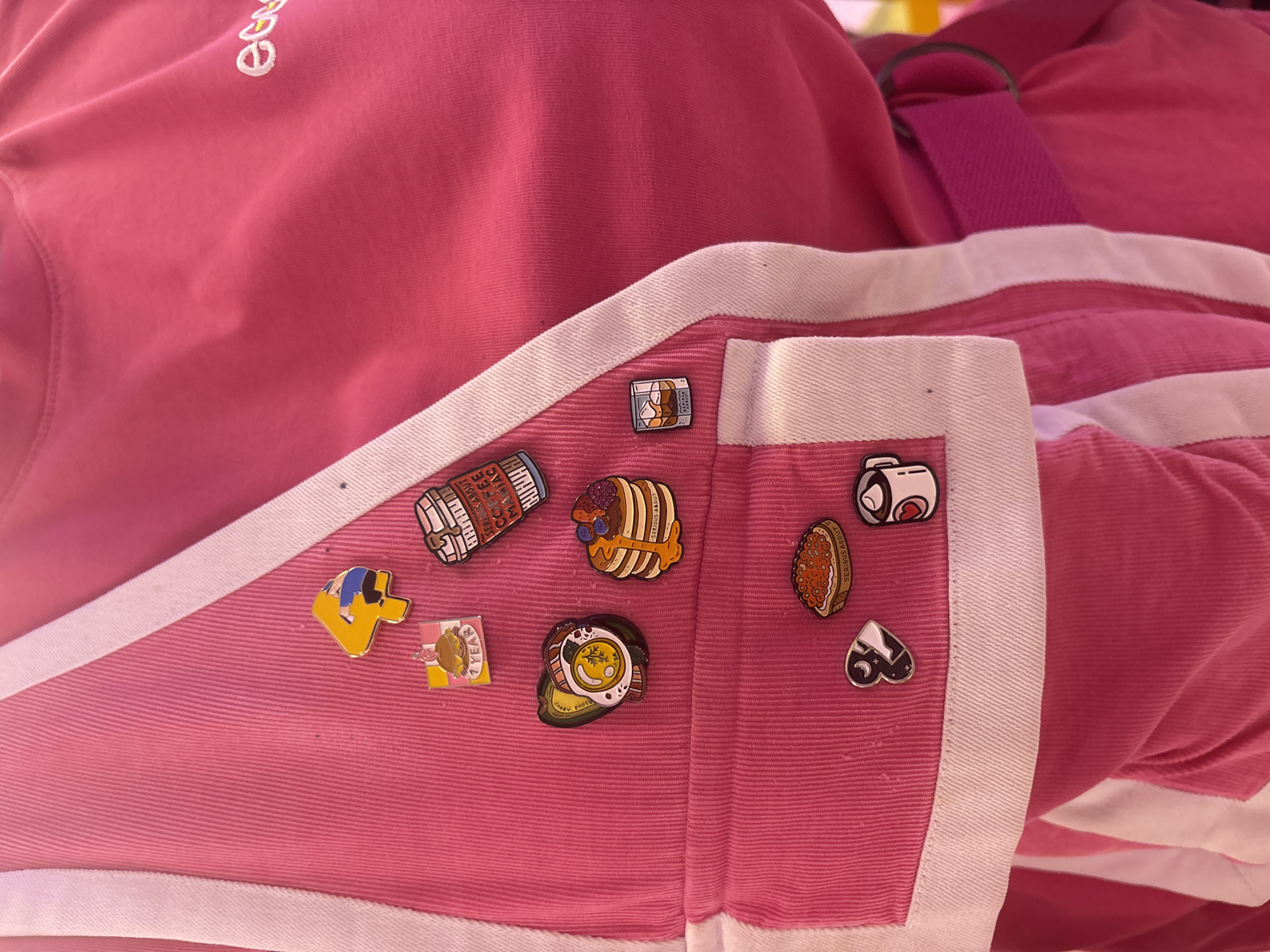Food-themed enamel pins spotted on pink garment in Moscow