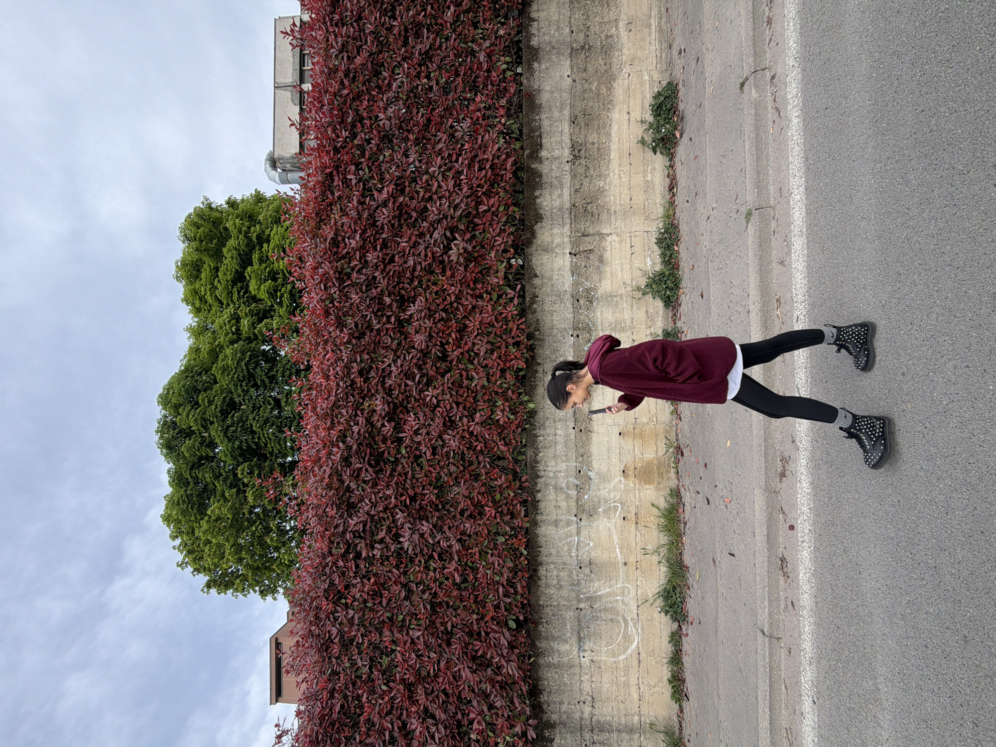 Person in maroon hoodie stands on Milan street