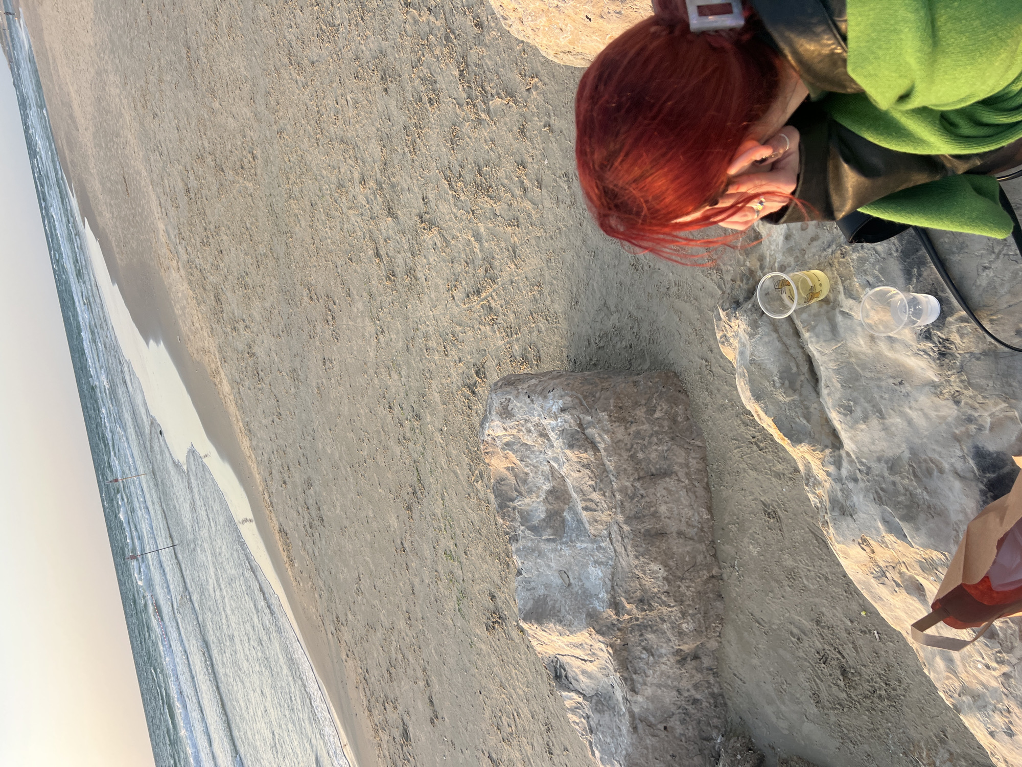 Woman sits on rocks at Bat Yam beach