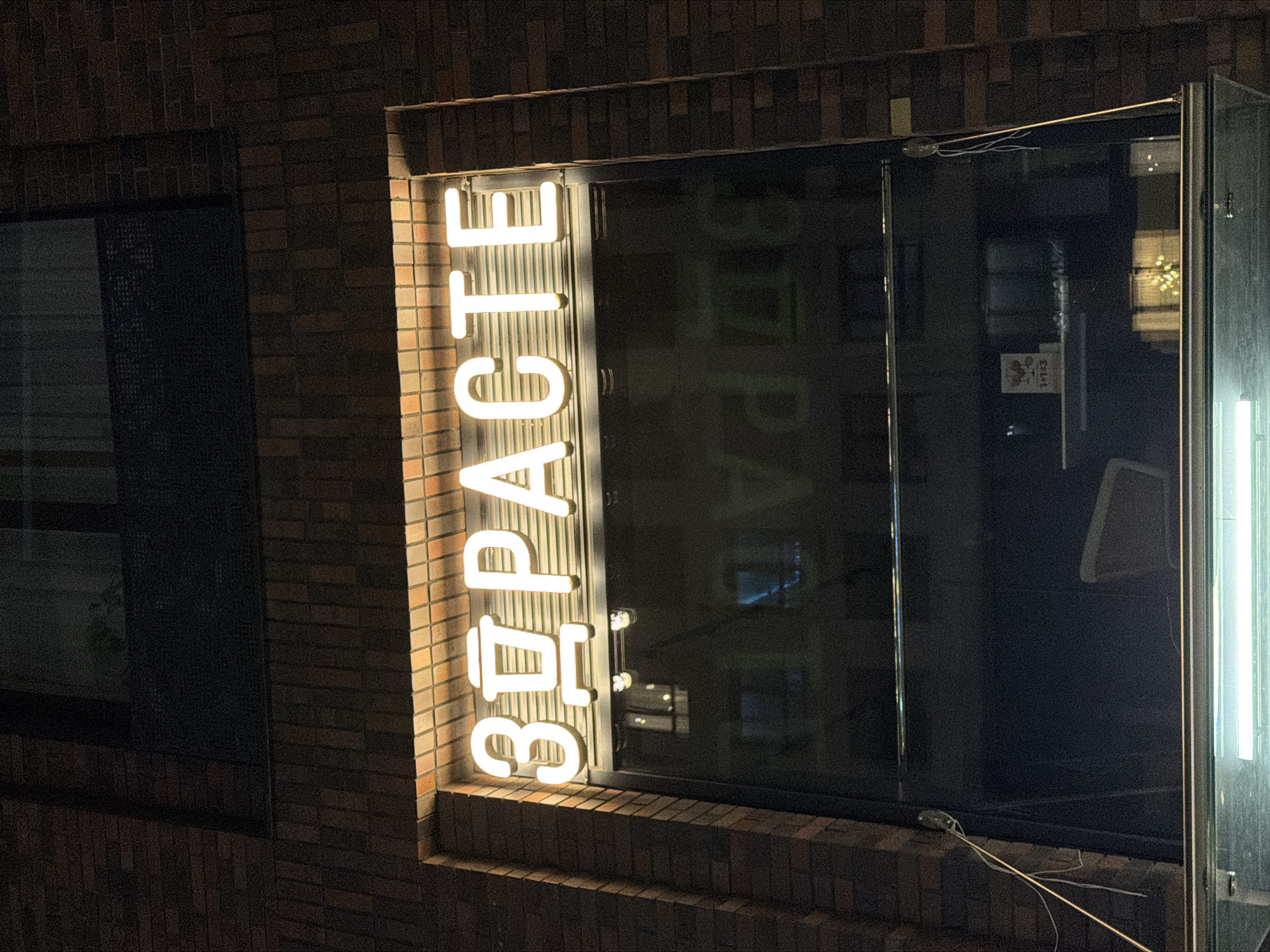 Neon signs, a barber mural, and a lit bridge in Moscow