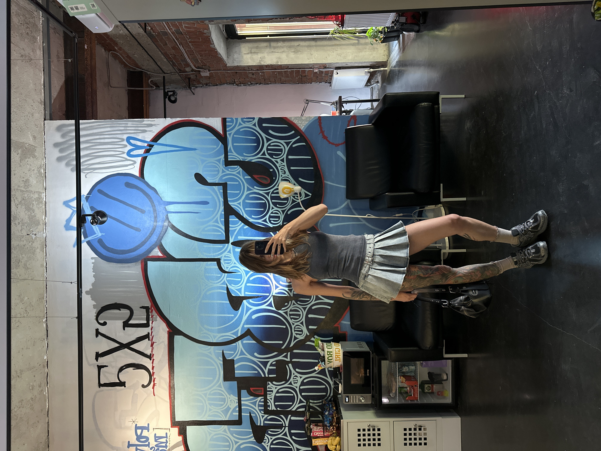 Woman takes selfies at graffiti-covered Moscow tattoo studio