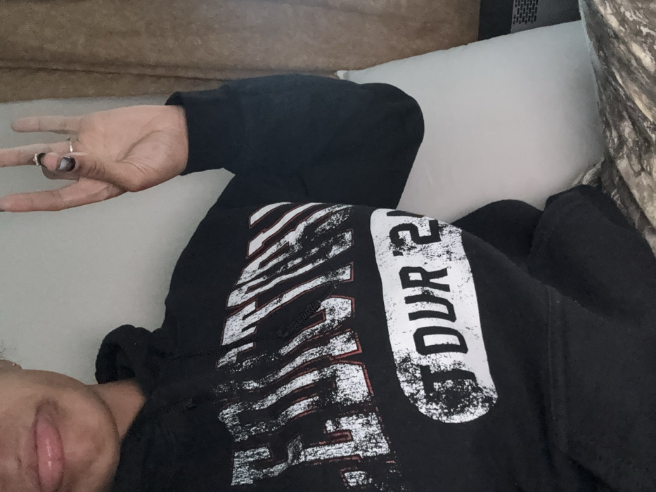 Person in tour hoodie rests on pillow in Yokosuka