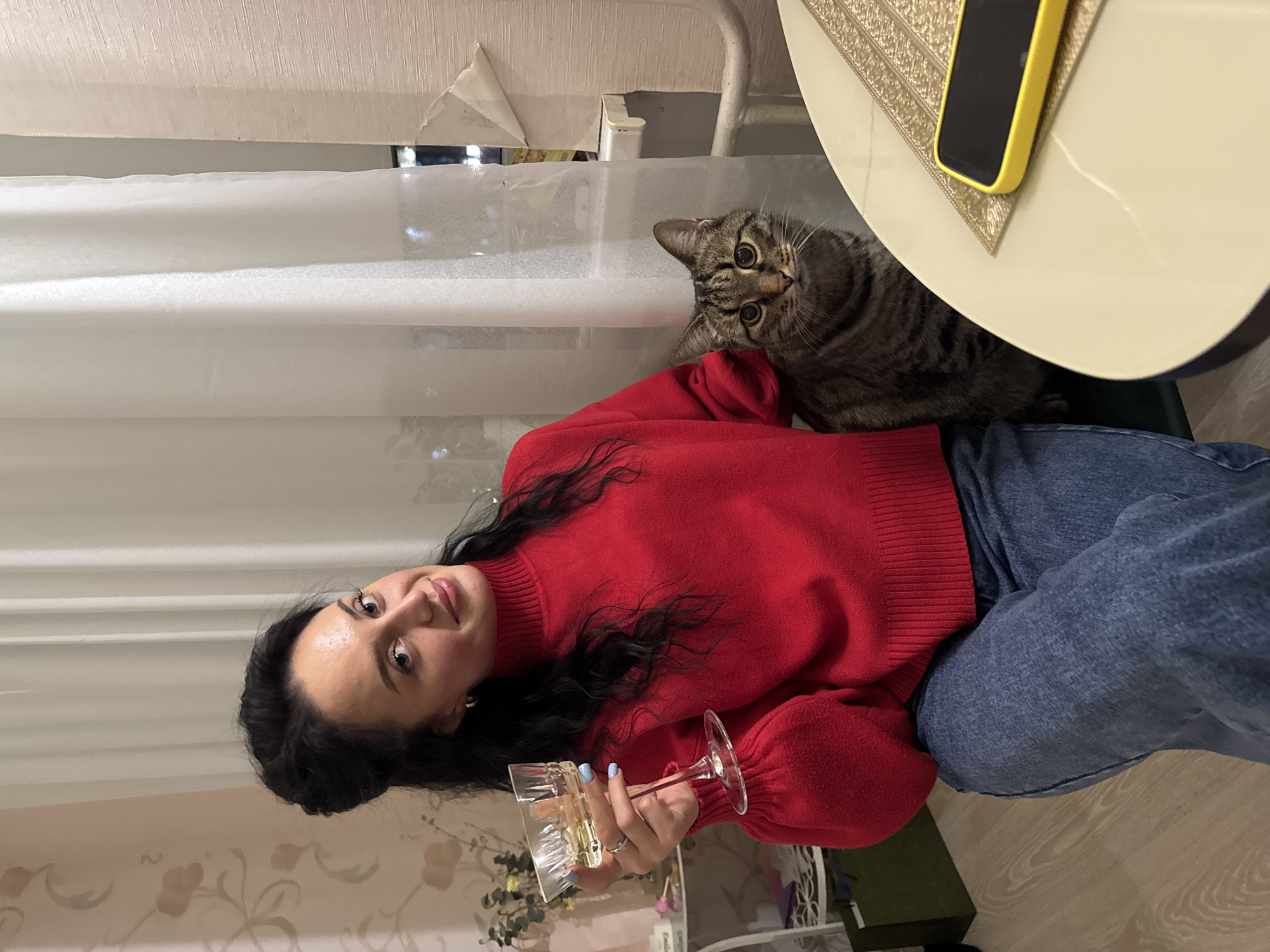 Woman in red sweater seated at home in Chaikovsky