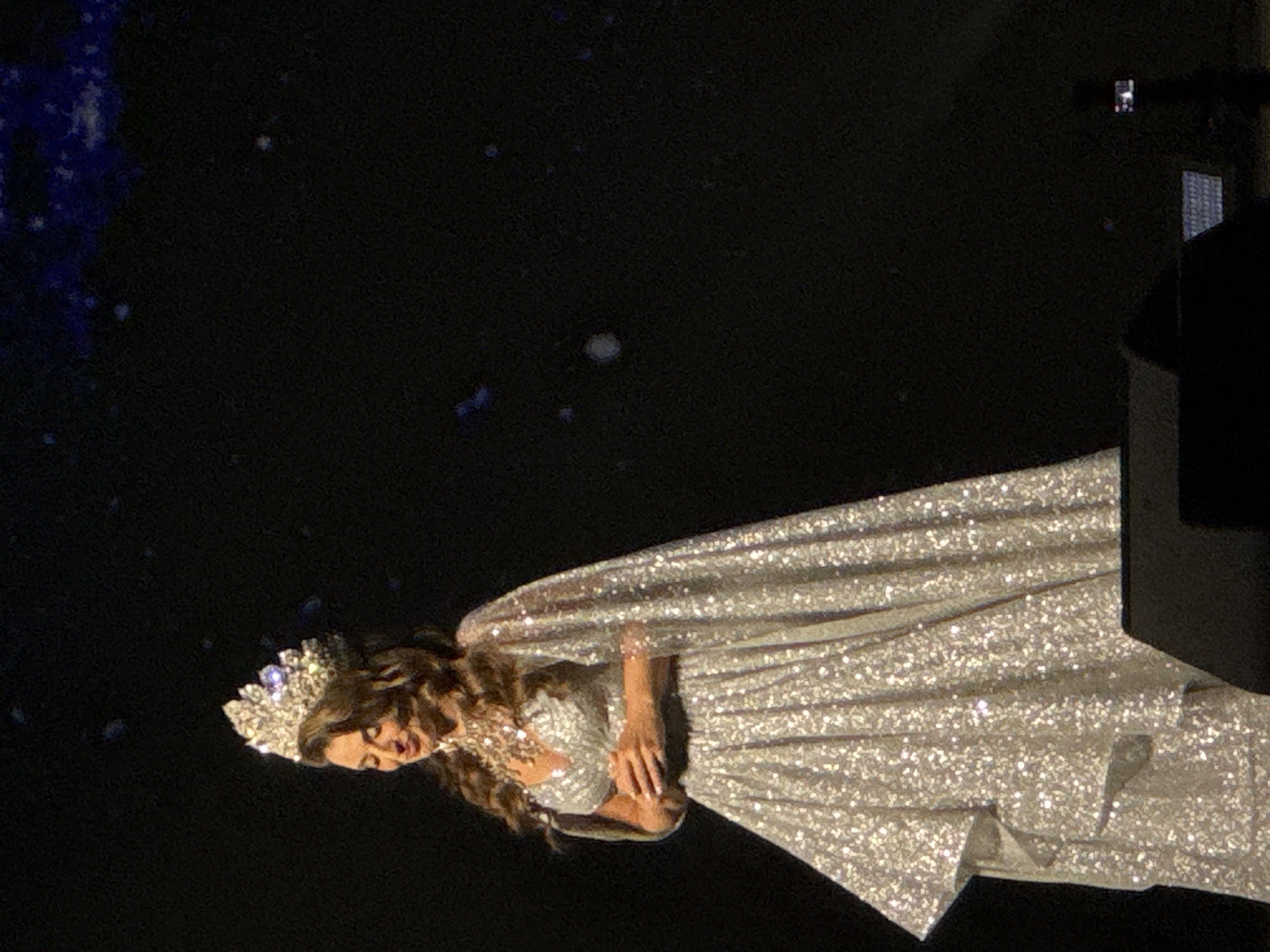 Beauty pageant contestant photographed on stage in evening gown