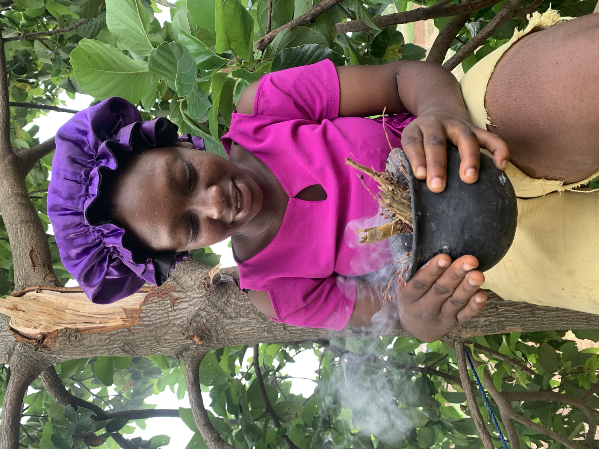 Woman conducts smoking ritual with pot in Agban, Nigeria