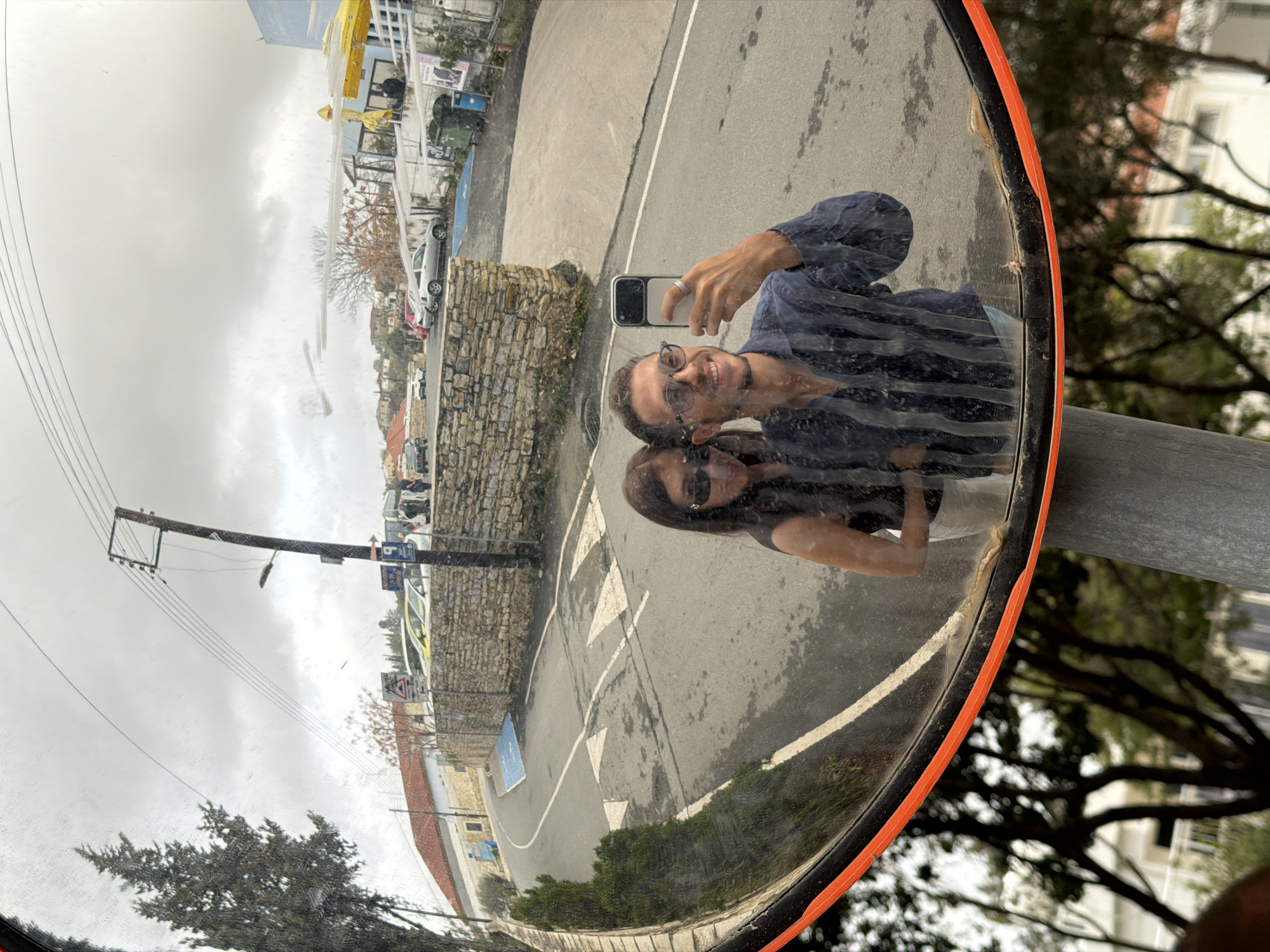 Couple takes selfies on cobblestone street in Cyprus village