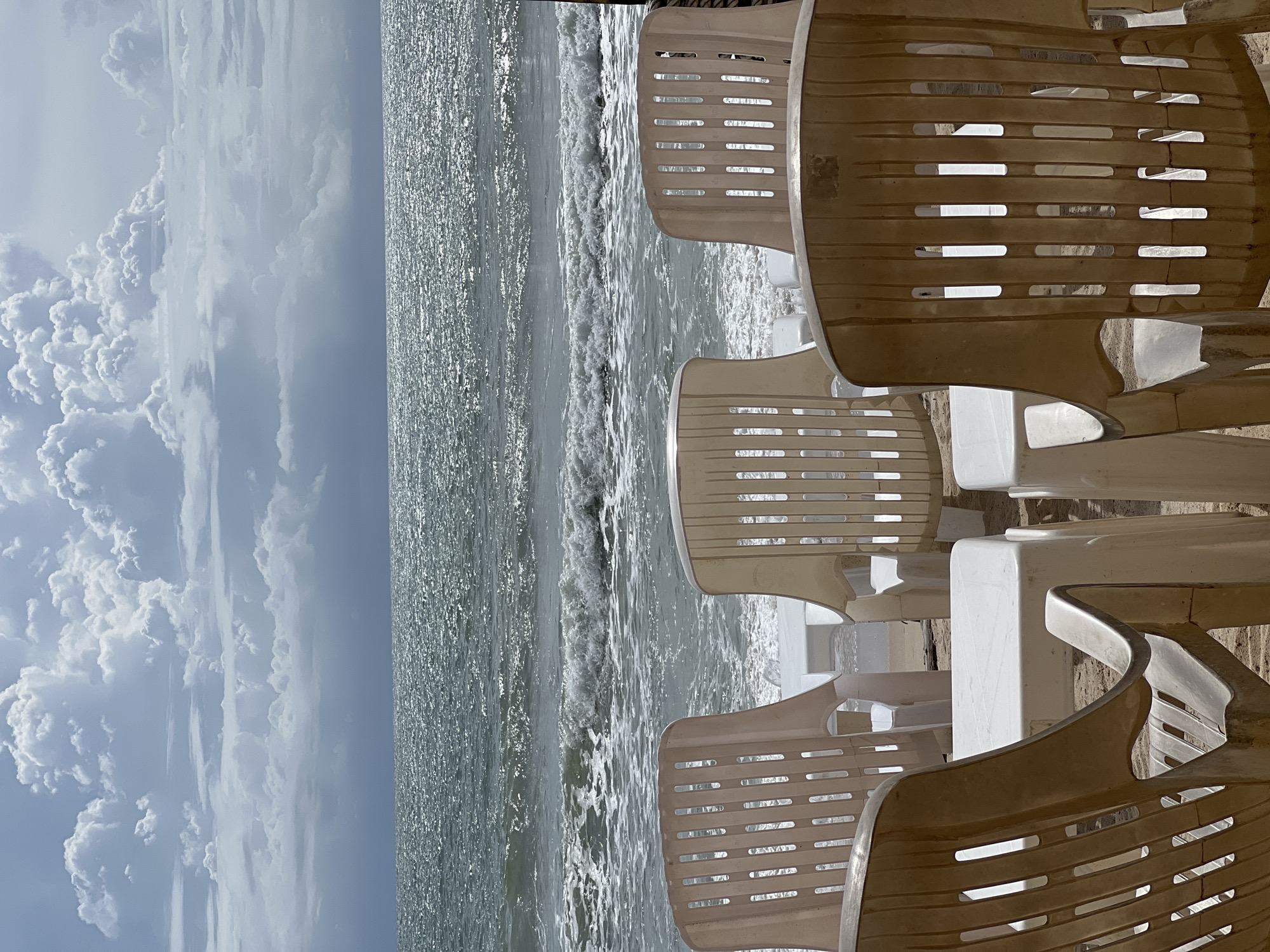 Empty beach furniture documented under cloudy skies Sunday morning