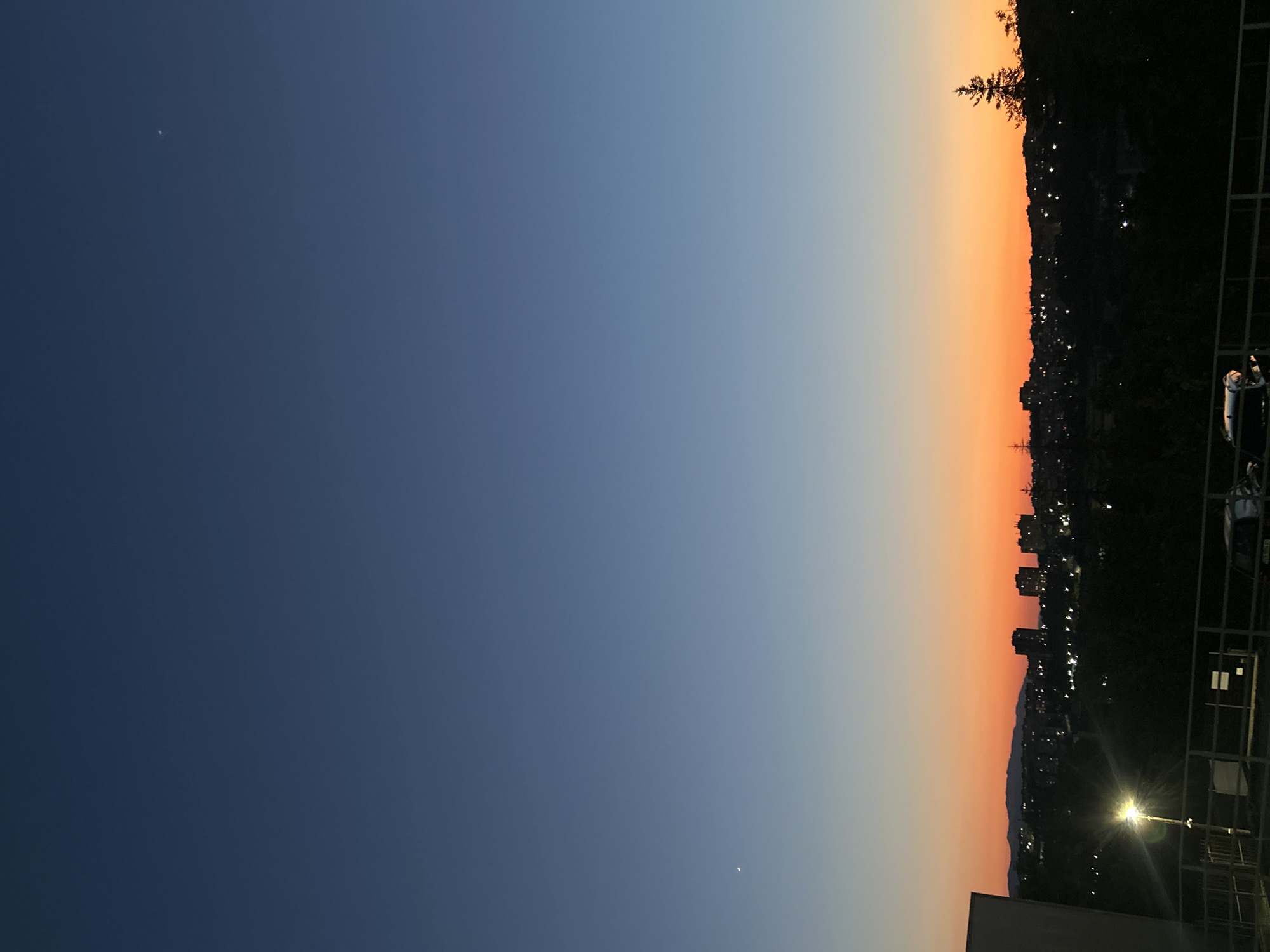 City skyline silhouetted against a dusk gradient sky