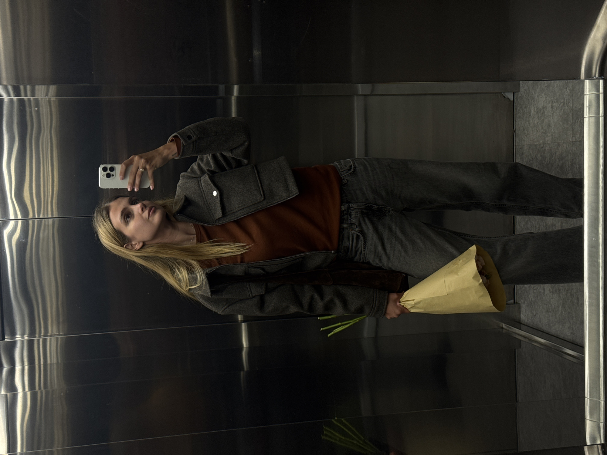 Woman takes flower bouquet selfie in Tbilisi elevator