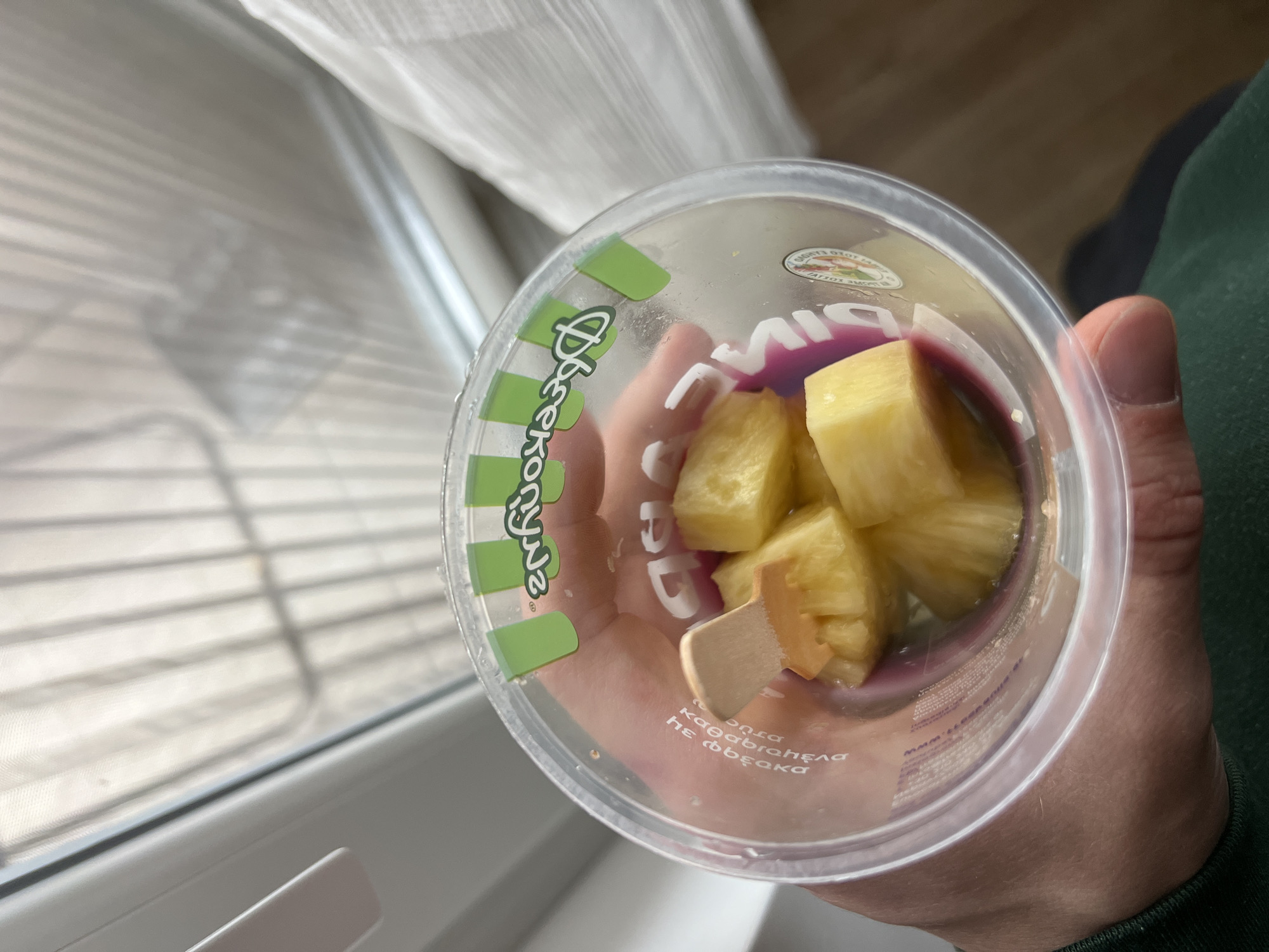 Person holds pineapple container with purple liquid in Burgas