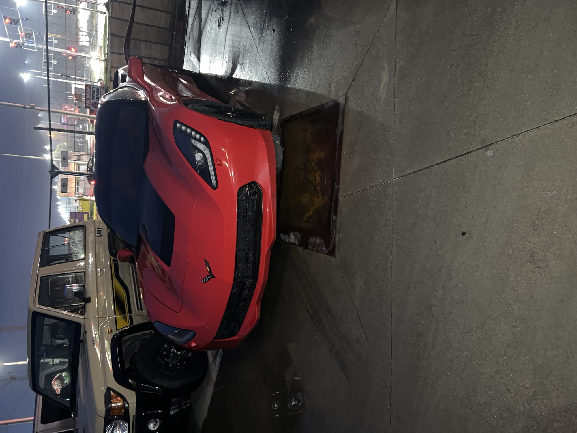 Red sports car parked over drain grate in Plovdiv