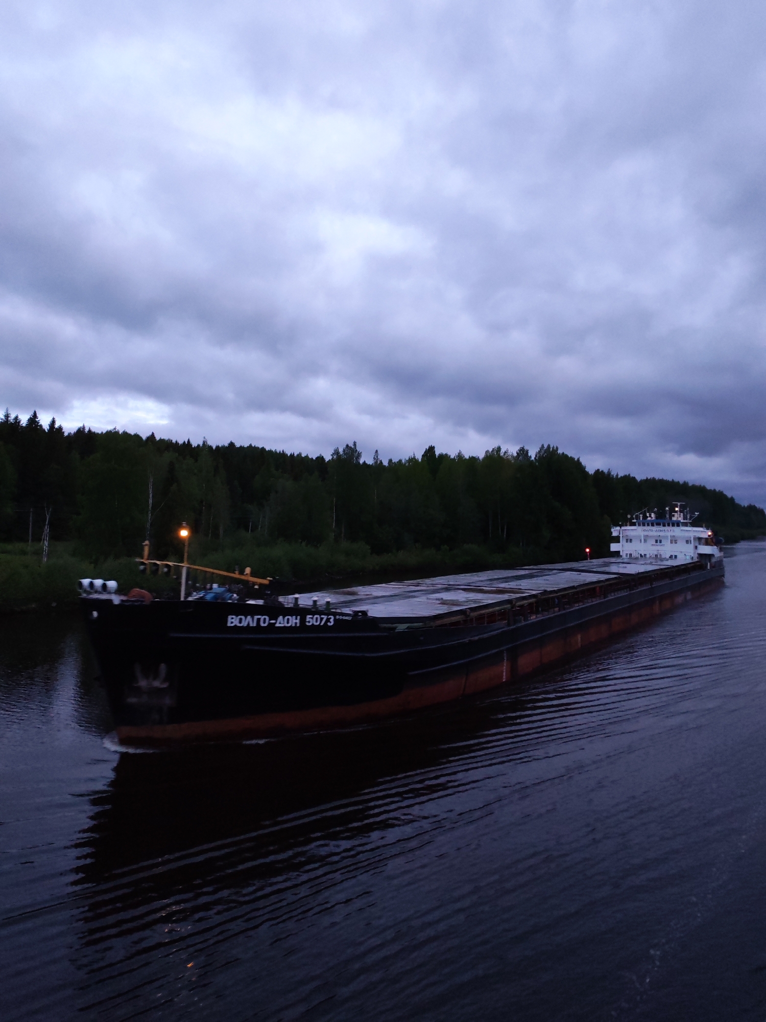 Commercial barges transit Russian waterways near Aleksandrovskoe under overcast skies