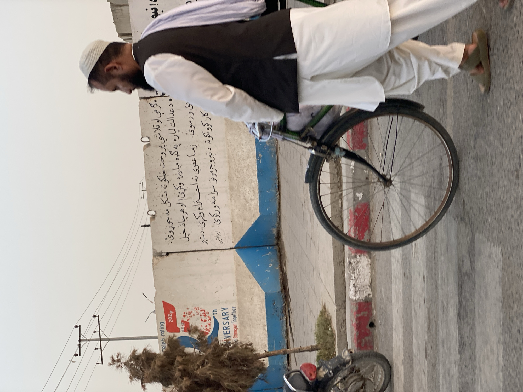 Street life in Kandahar: foot traffic, bikes, and a rickshaw