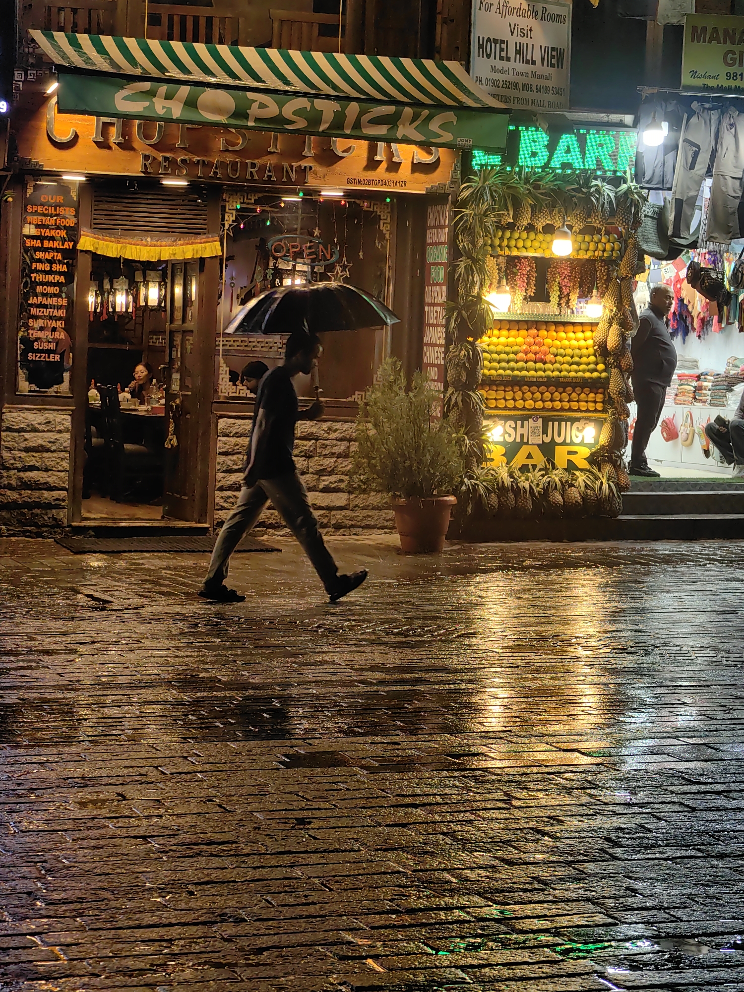 Rainy night on Manali's Mall Road, neon-lit and busy
