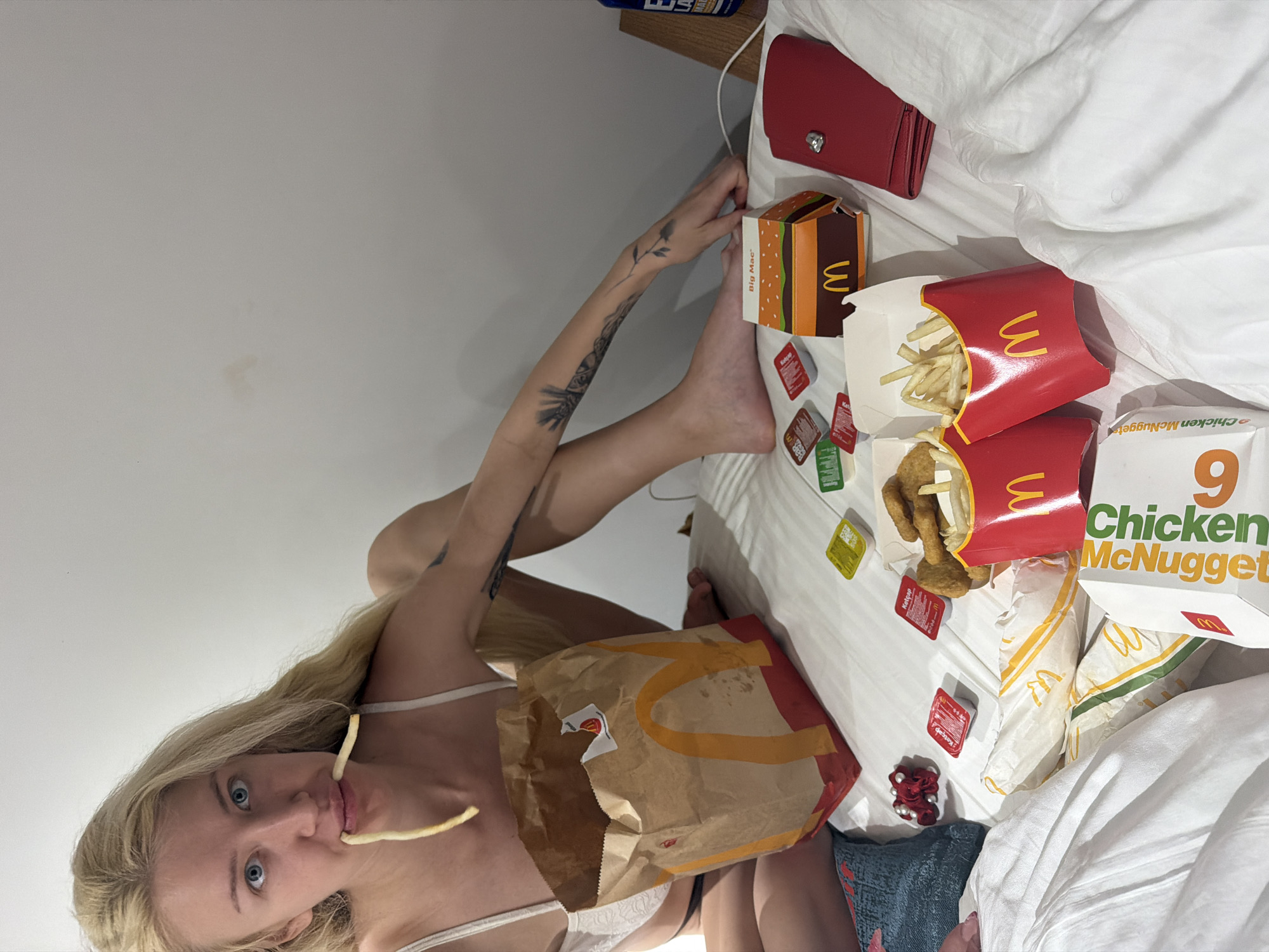 Woman eating McDonald's on hotel bed in Istanbul