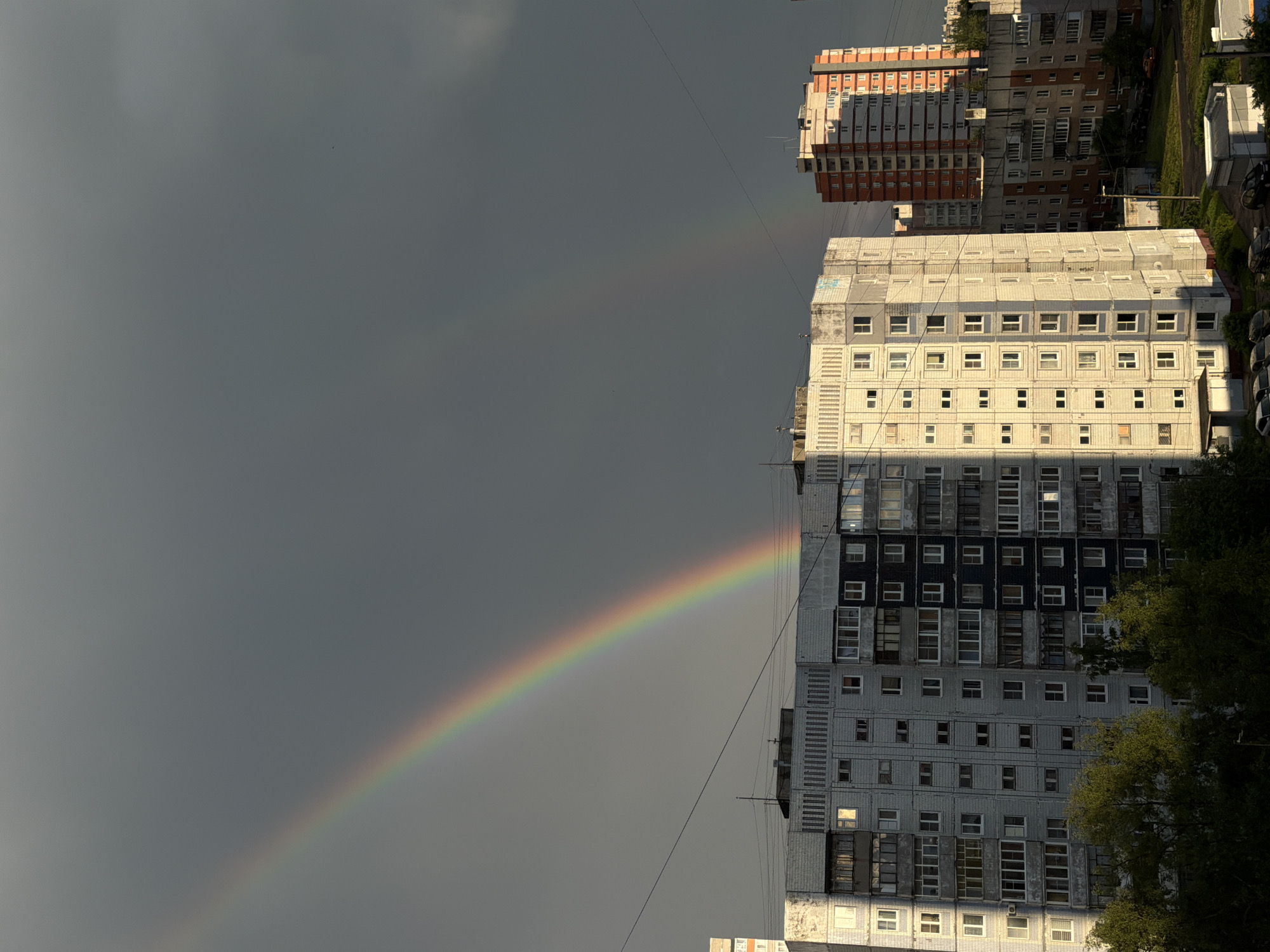 Double rainbow over wet streets in Rusanovo after summer rain