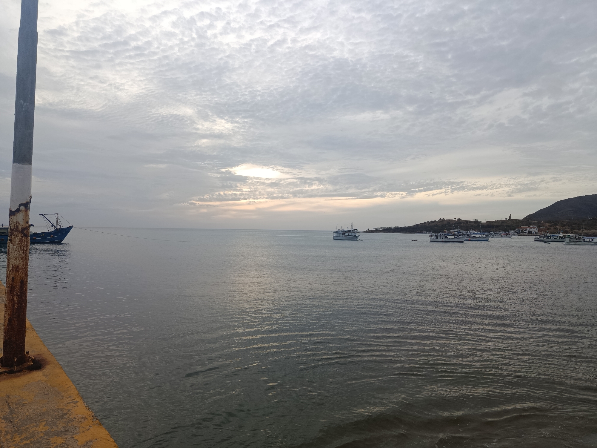 Evening documentation of Juan Griego waterfront shows boats, pedestrians