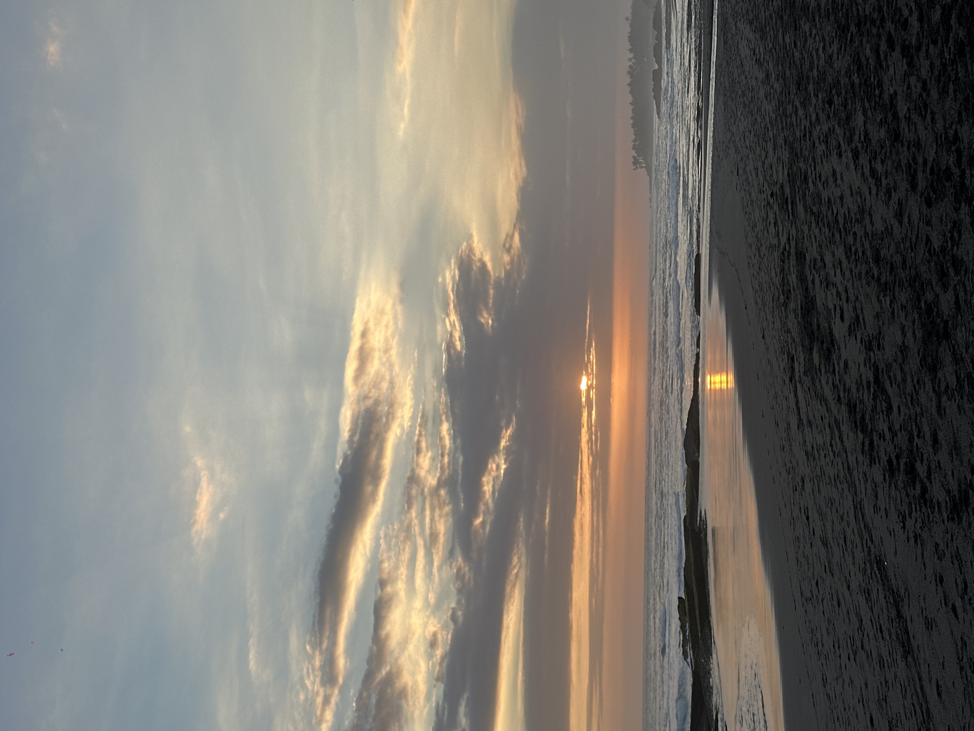 Surfing and sunset vibes at a tropical dark-sand beach