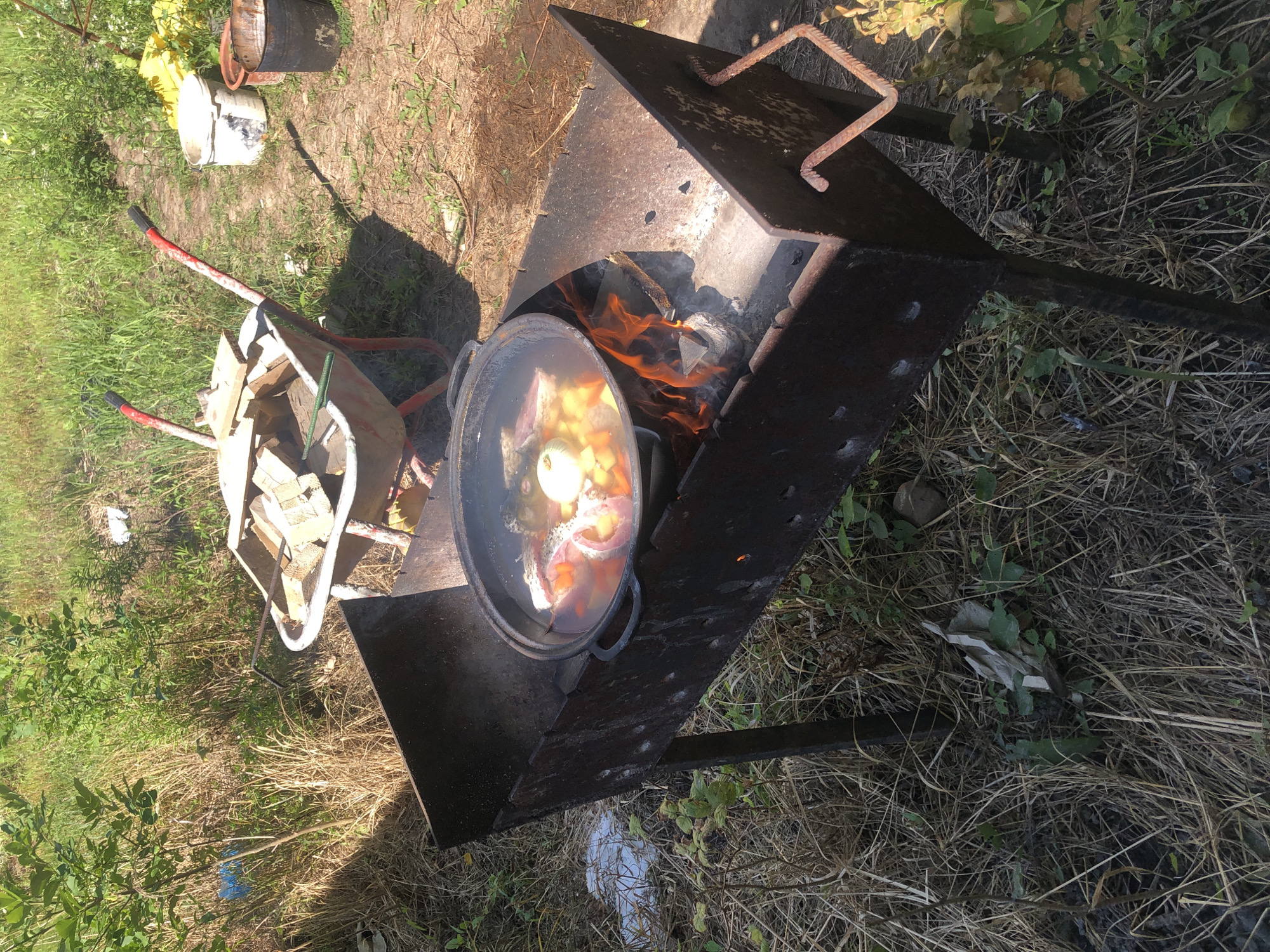 Open-fire cooking with cast iron pots in Lviv backyard