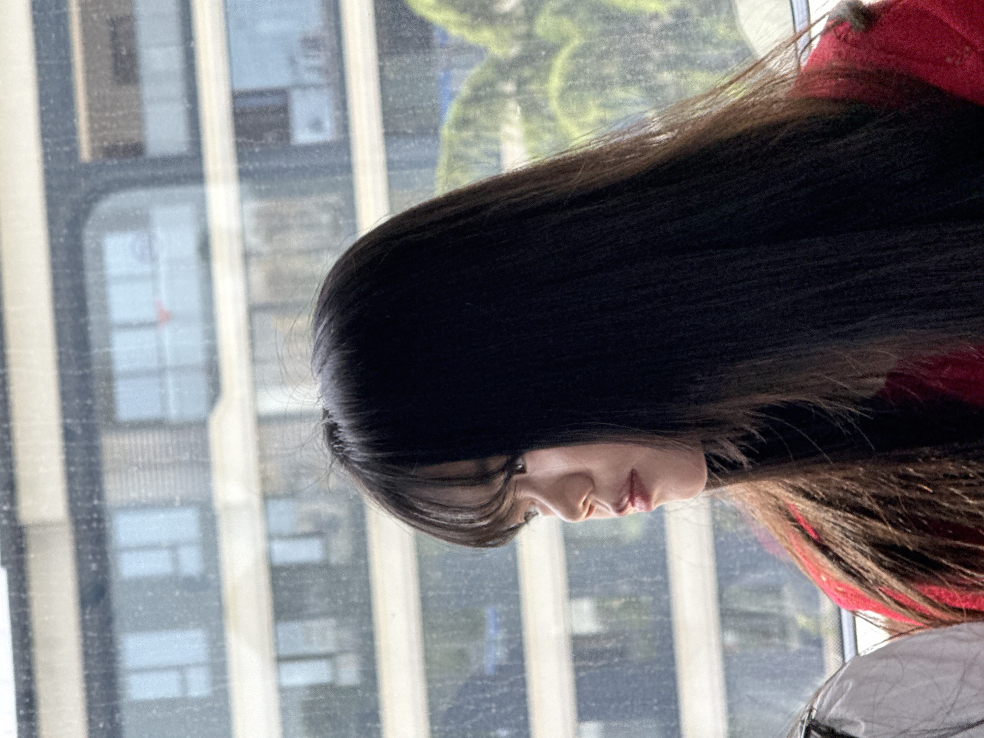 Person gazes at cityscape through window in Shuangfu