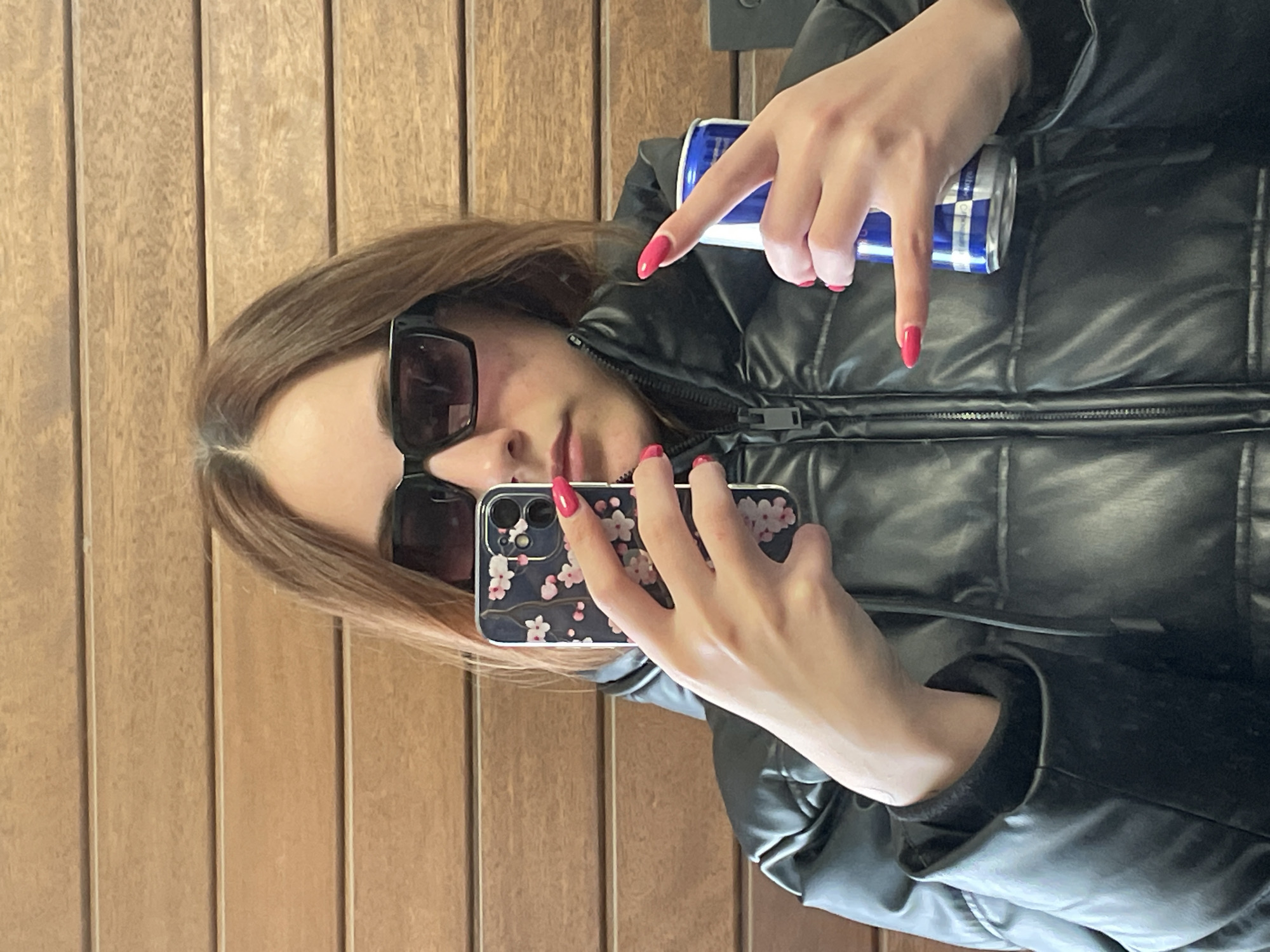 Woman takes selfie against wood wall in Sofia