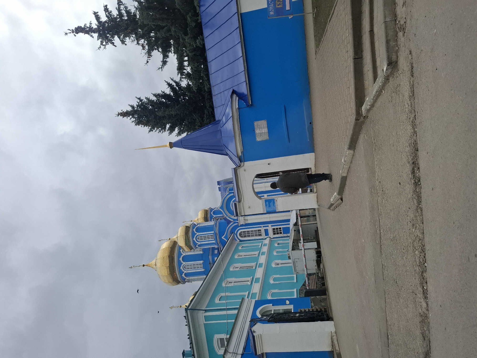 Pedestrians cross street near Orthodox monastery in Zadonsk, Russia